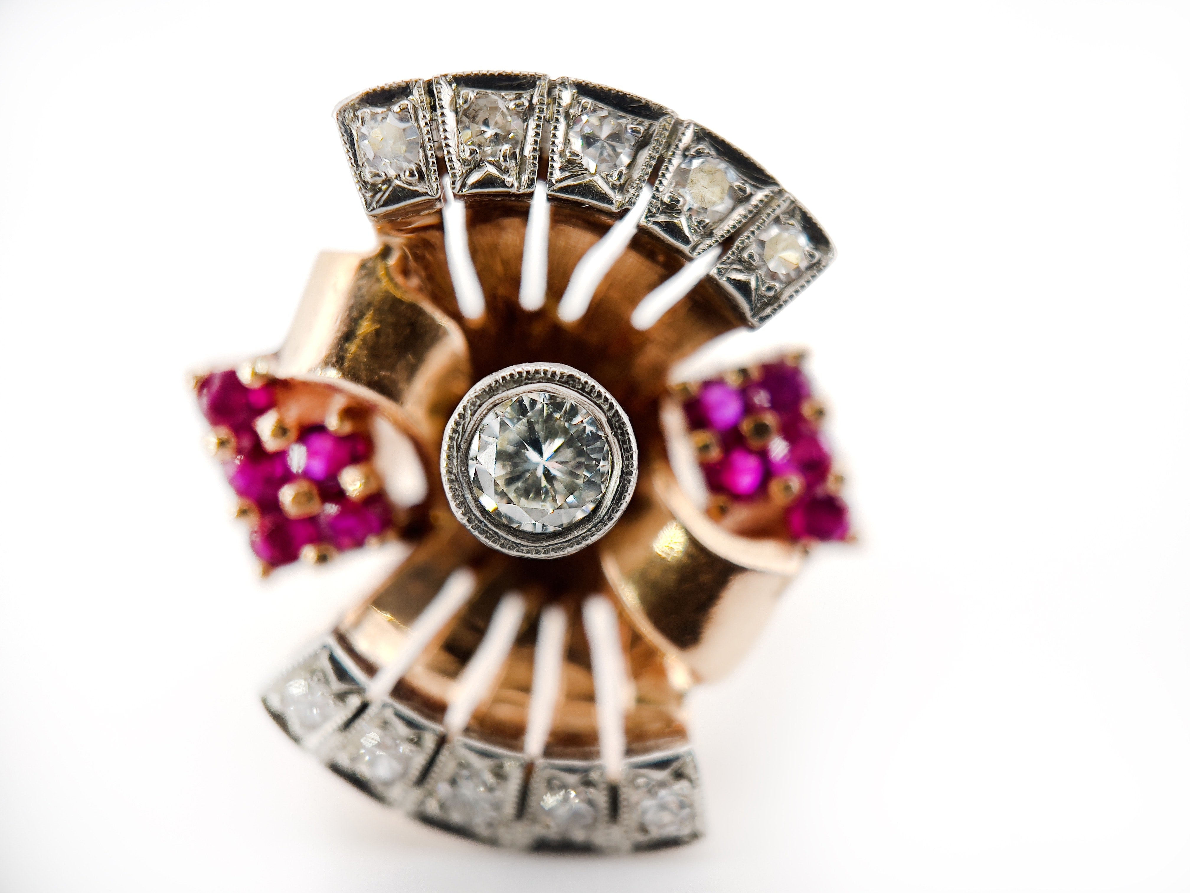 Elegant retro rose gold and palladium ring with diamonds and rubies against a white background.