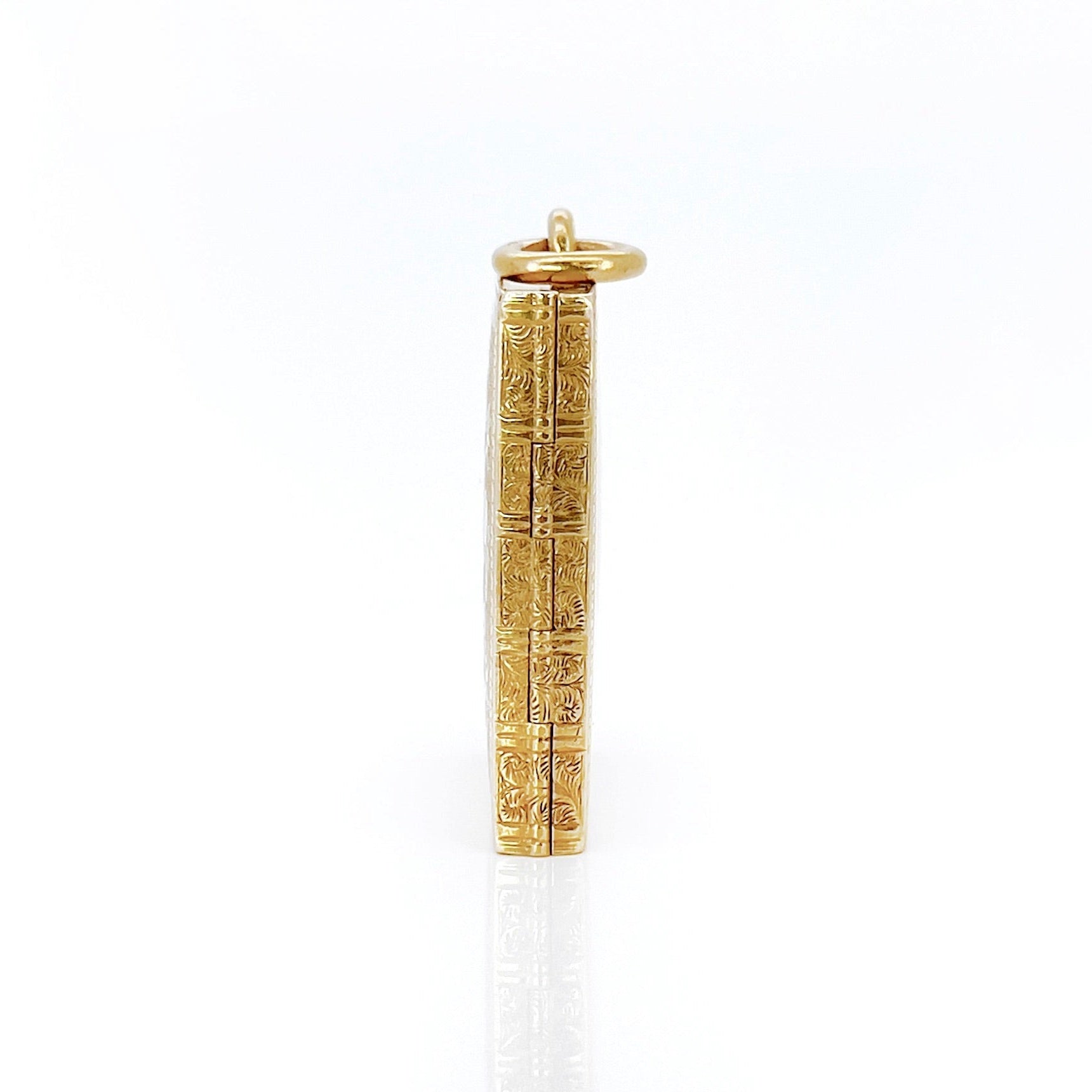 Gold Victorian book locket with intricate design against a white background