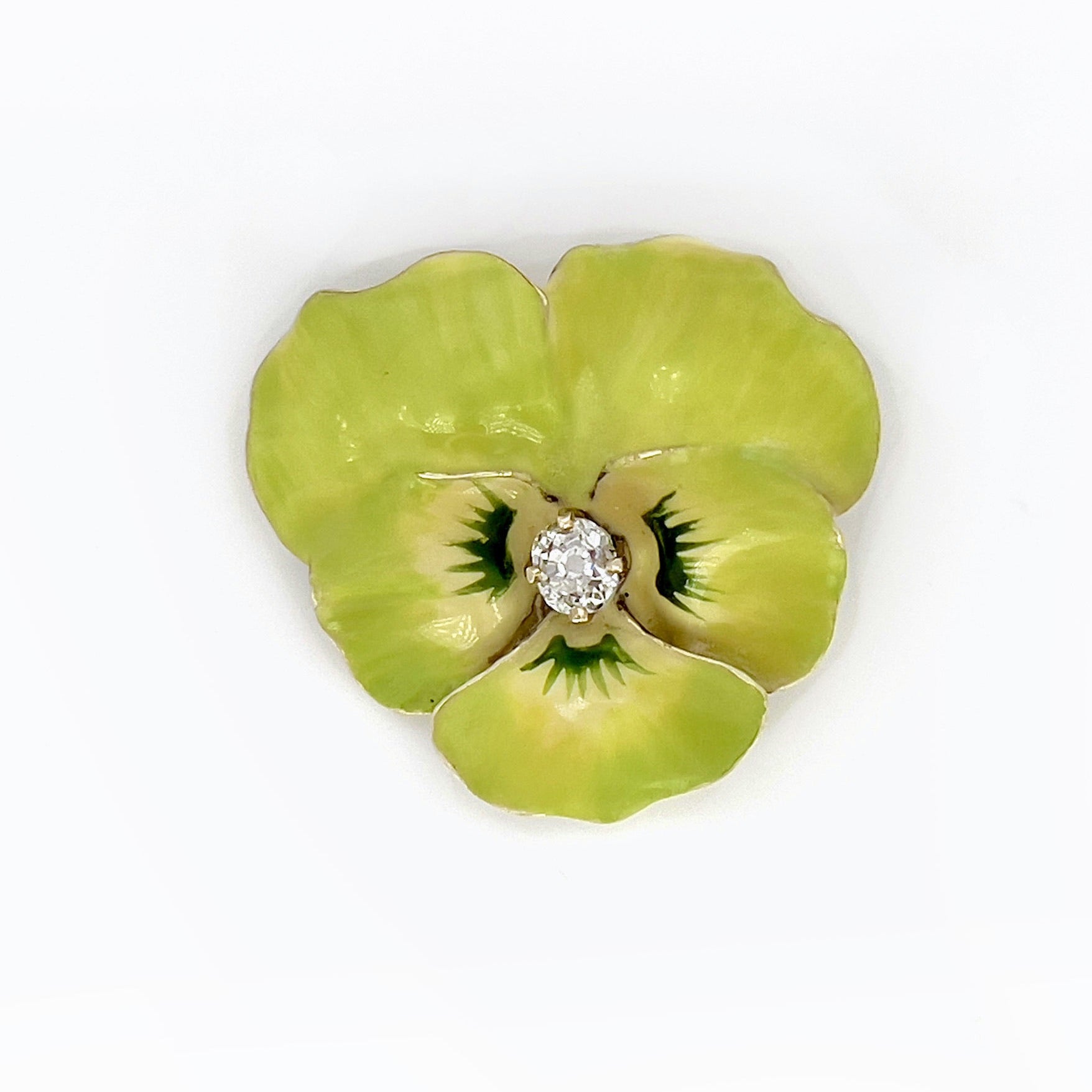 A Victorian lime green Pansy brooch with a 14K yellow gold setting and a central old mine cut diamond, on a white background.
