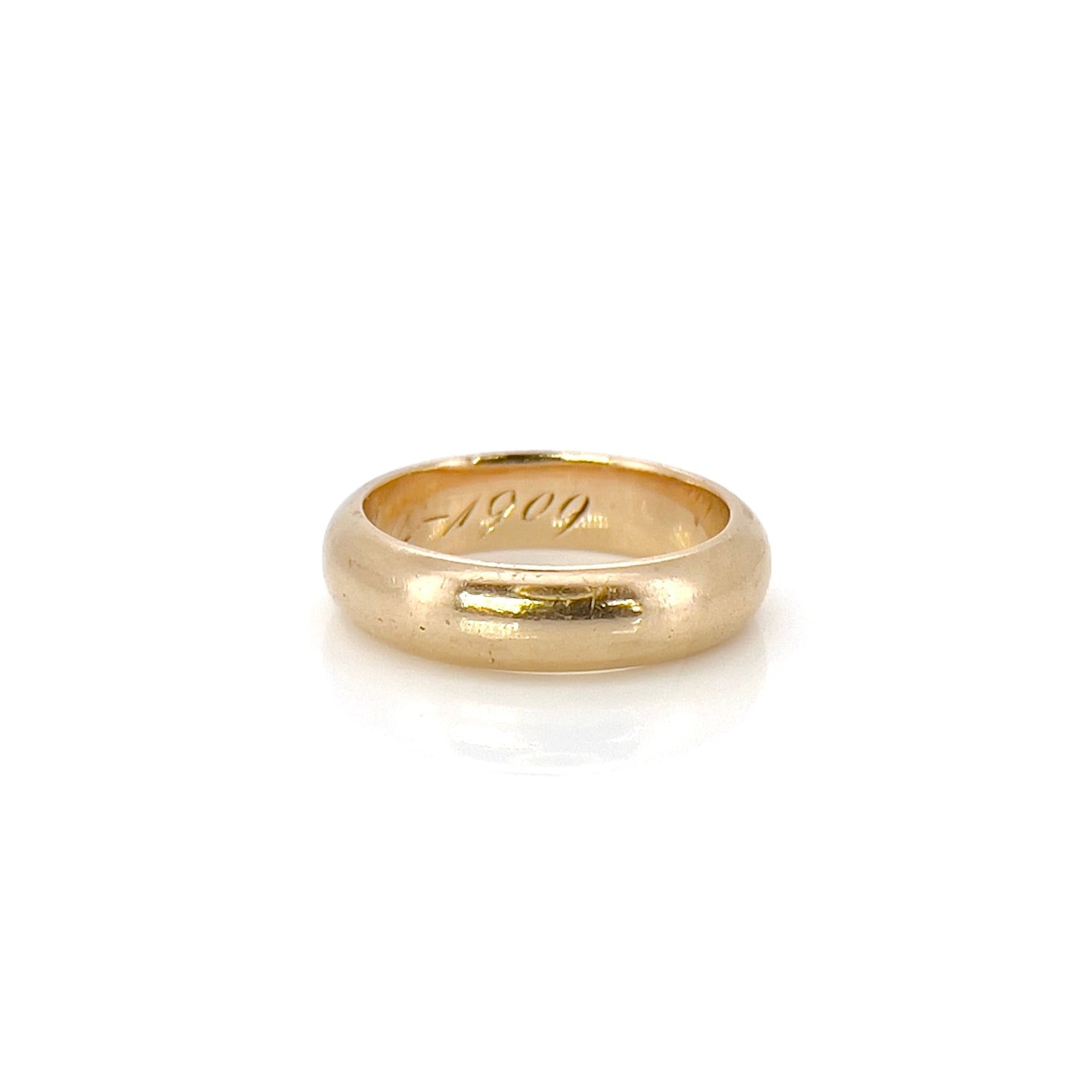 An antique gold band with an inscription, displayed against a white background.