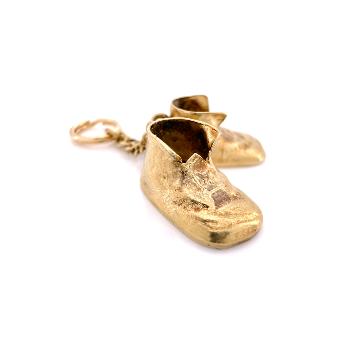 A pair of miniature gold baby boot charm with a textured finish and a small gold chain link, shown on a plain white background.