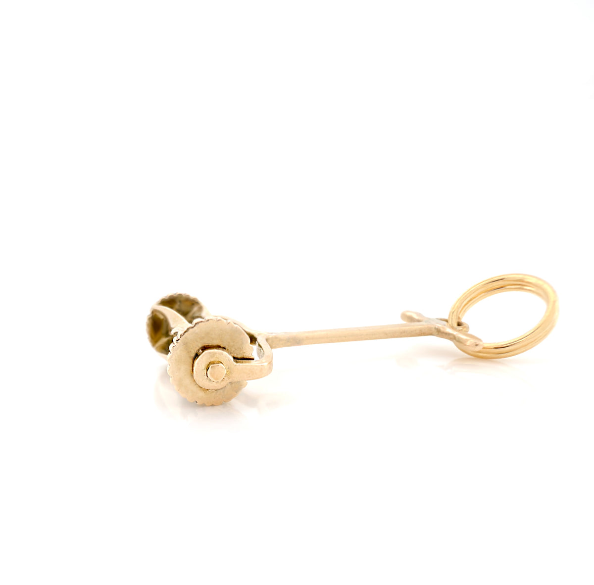 Side view of a small gold hand push lawn mower charm with a circular loop at the top, on a plain white background.