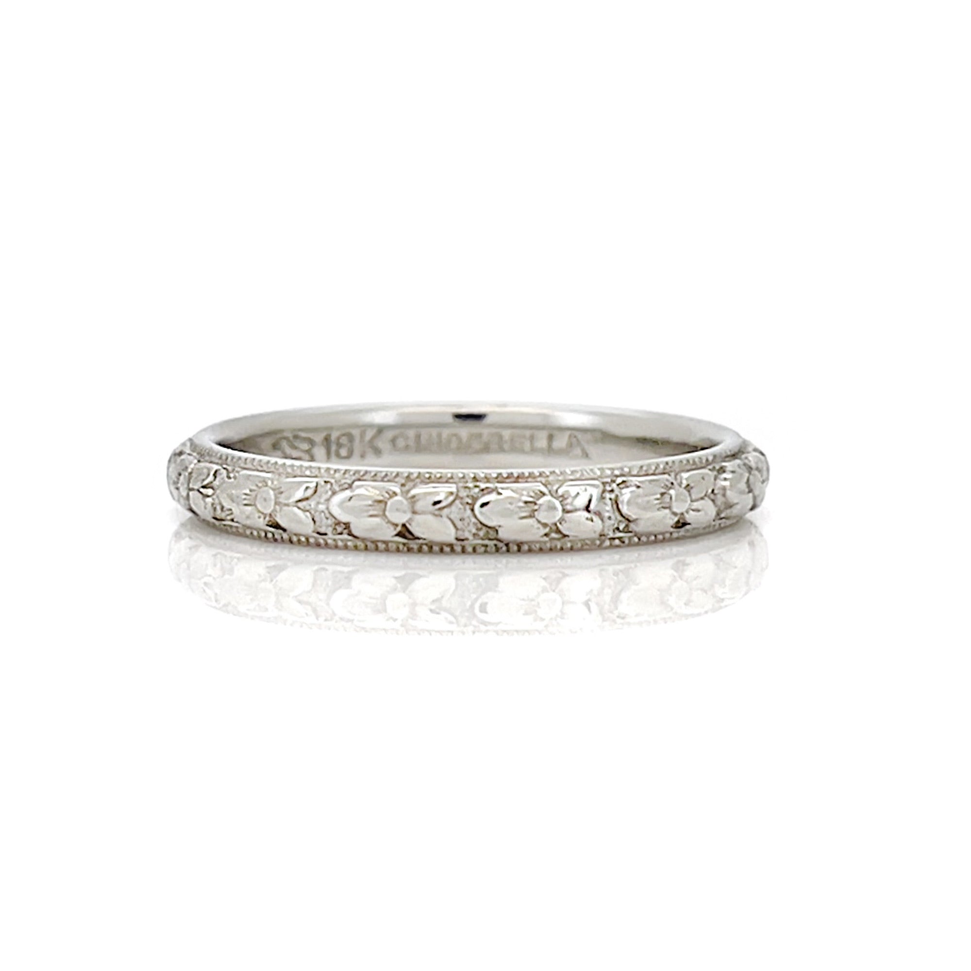 White gold vintage ring with floral design on a white background