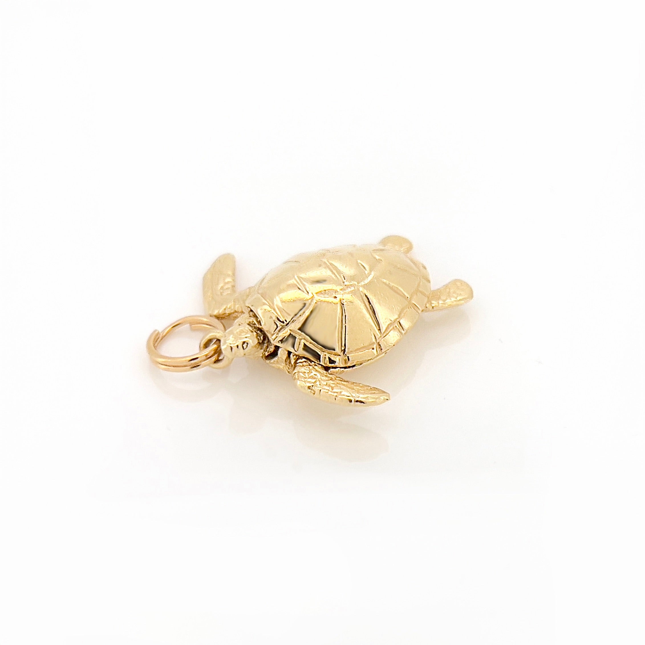 Gold turtle charm on a white background