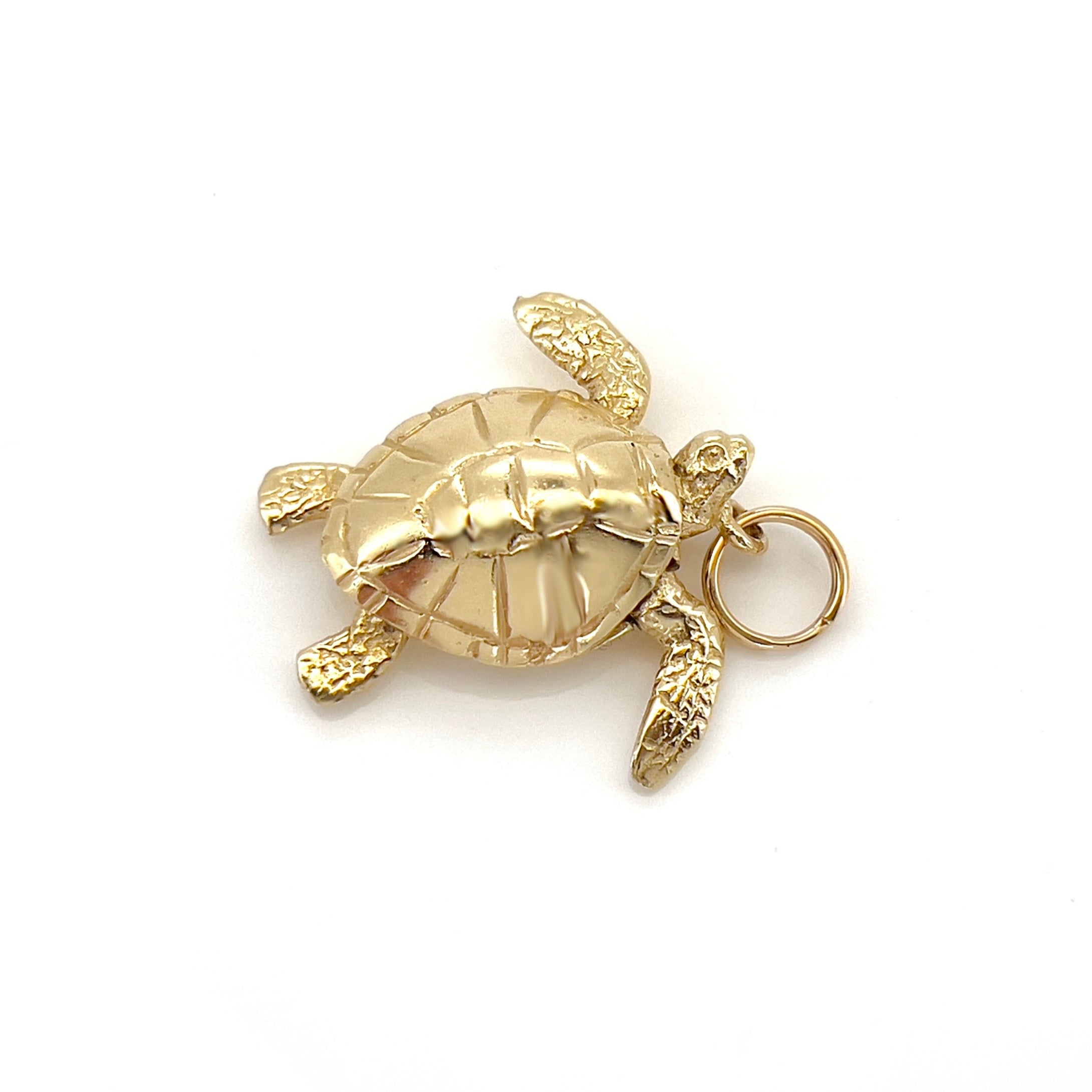 Gold turtle charm on a white background