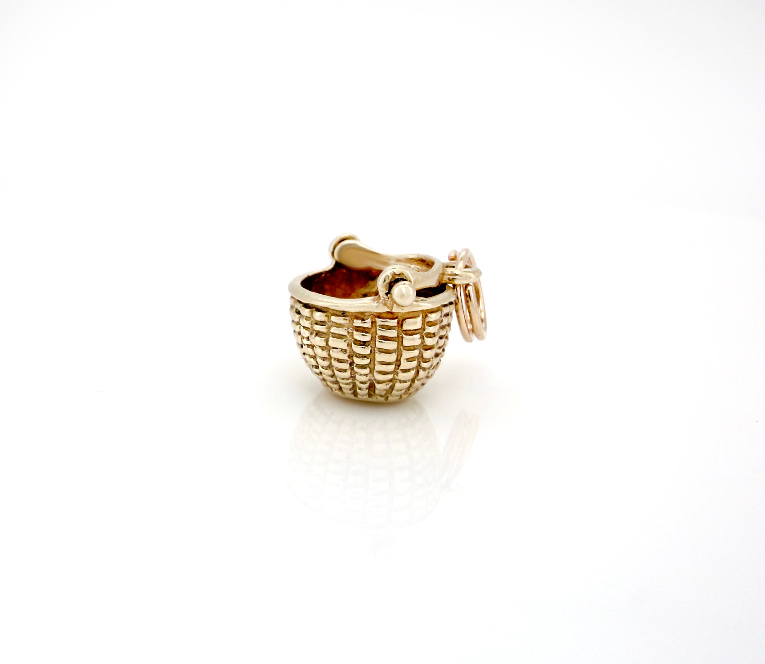 Gold charm shaped like a woven basket on a white background