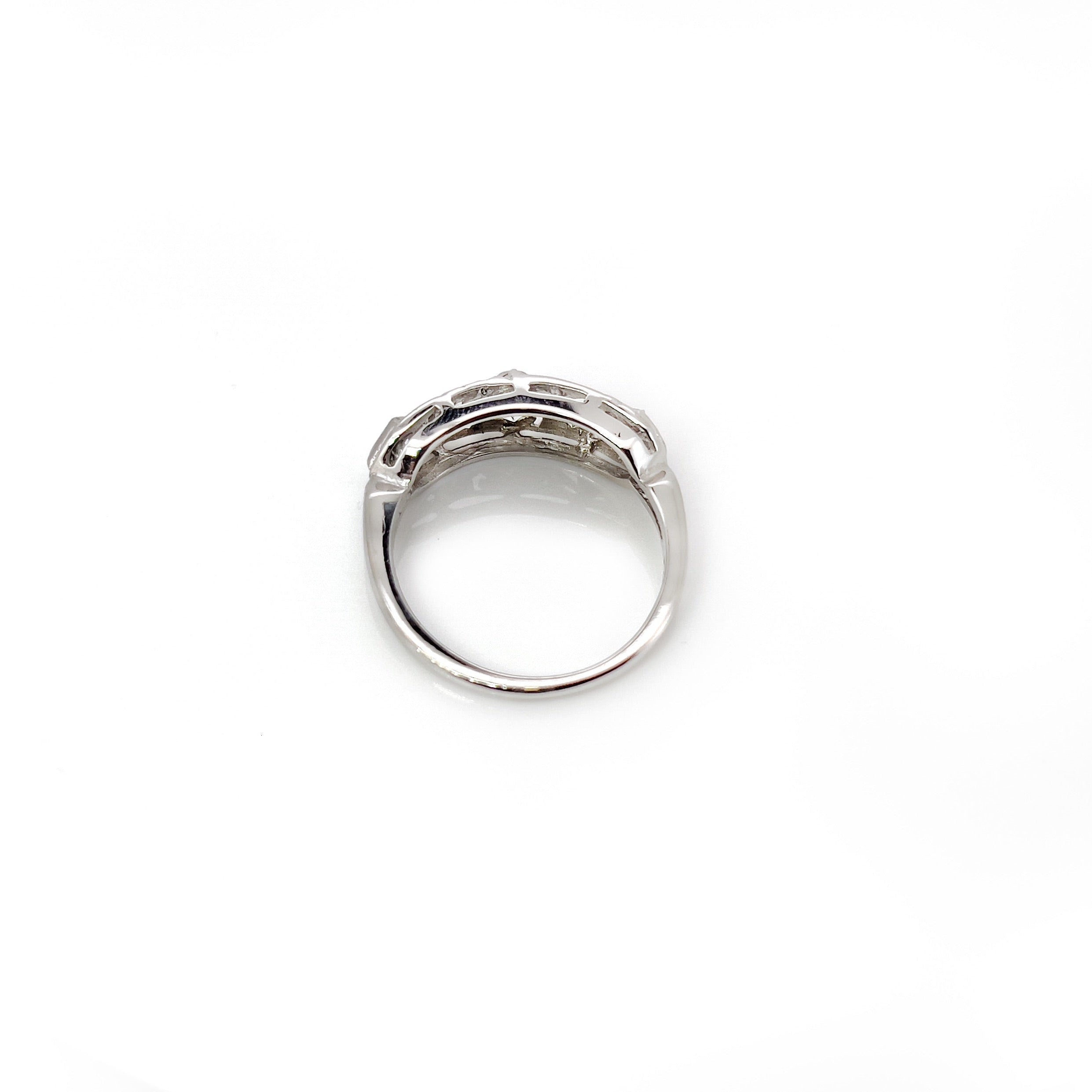 A vintage white gold ring with a central transitional cut diamond flanked by old European cut diamonds, with intricate engraving.