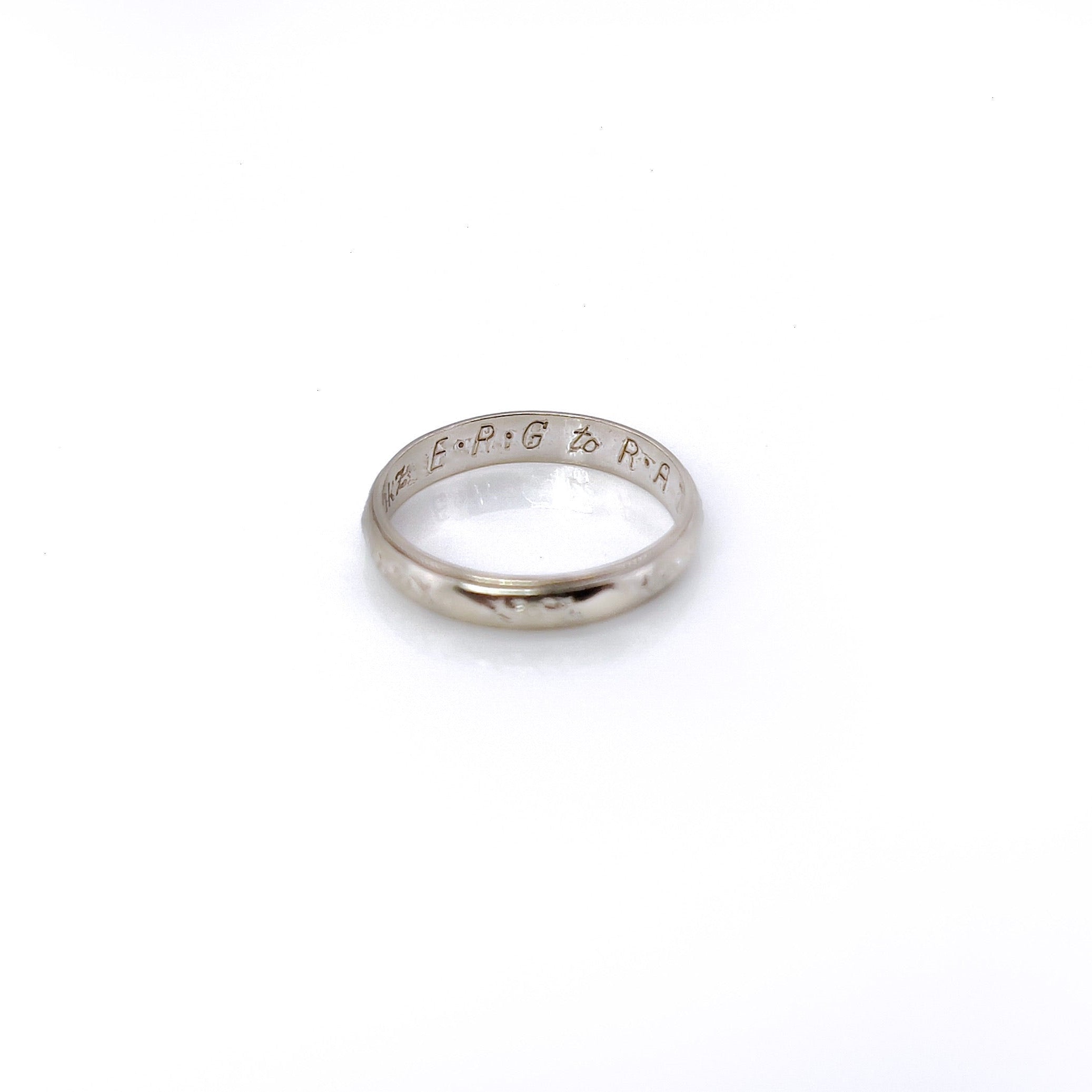 A vintage white gold ring with faint orange blossom design and milgrain pattern, size 5.25, with visible wear.