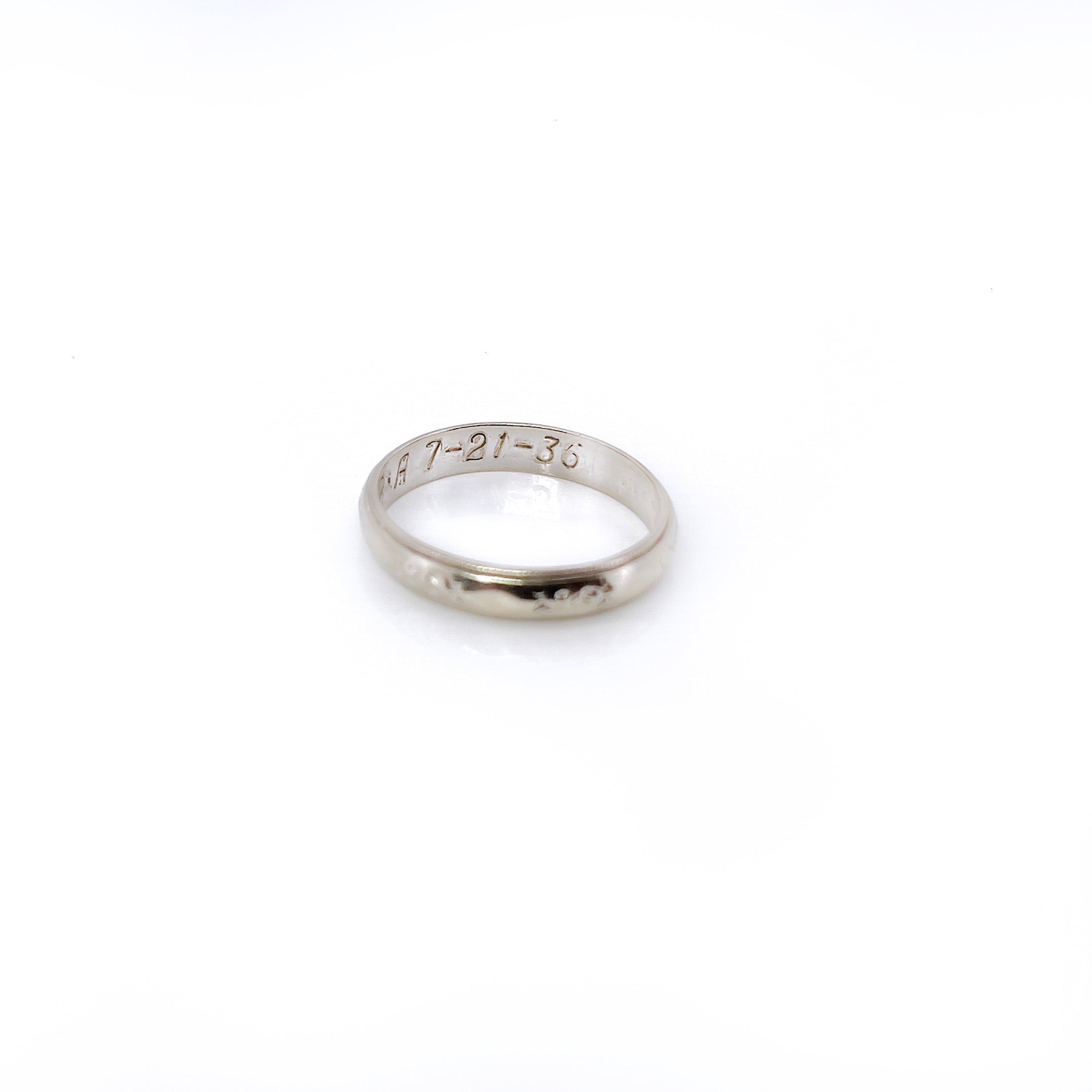 A vintage white gold ring with faint orange blossom design and milgrain pattern, size 5.25, with an inscription.