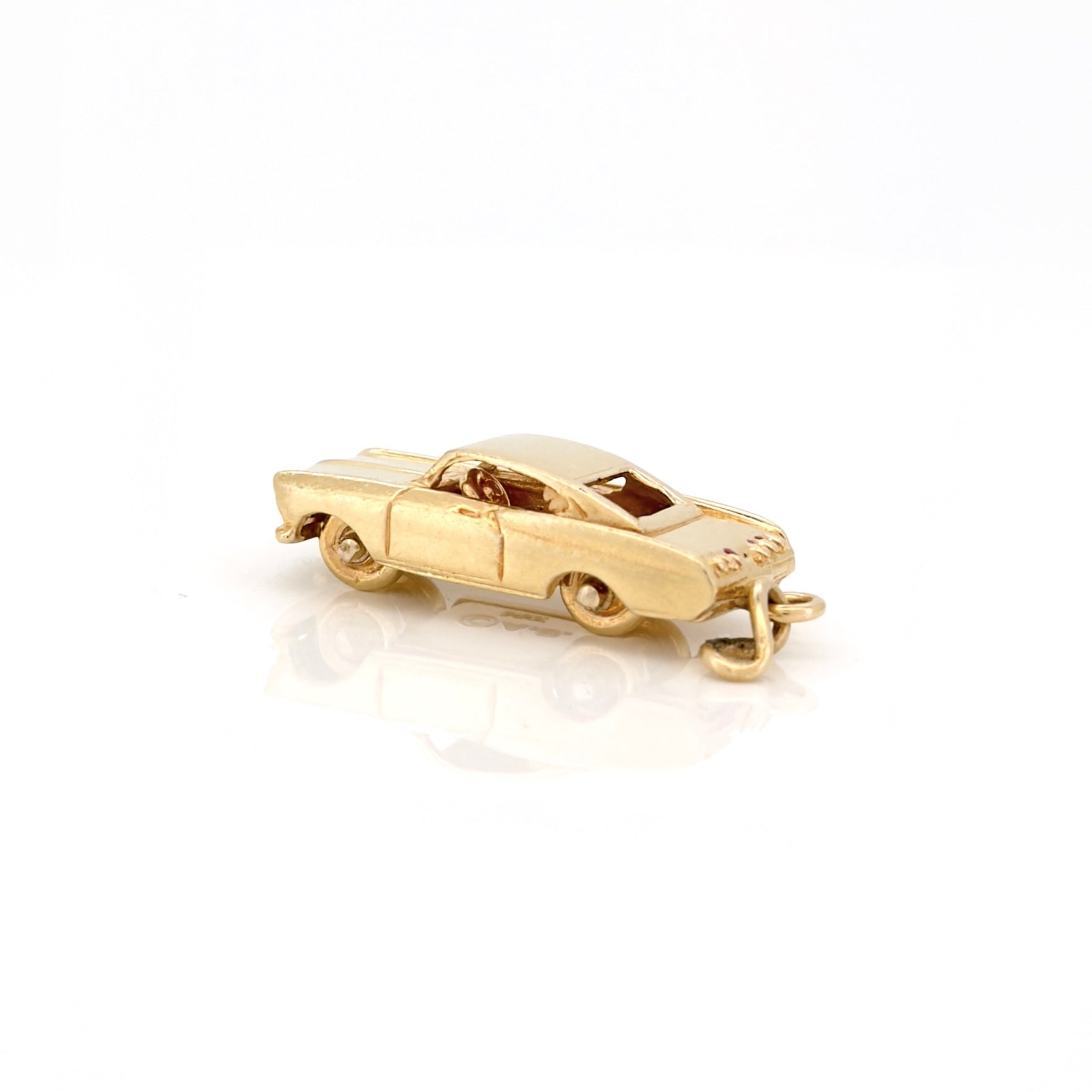 Gold car-shaped charm on a white background