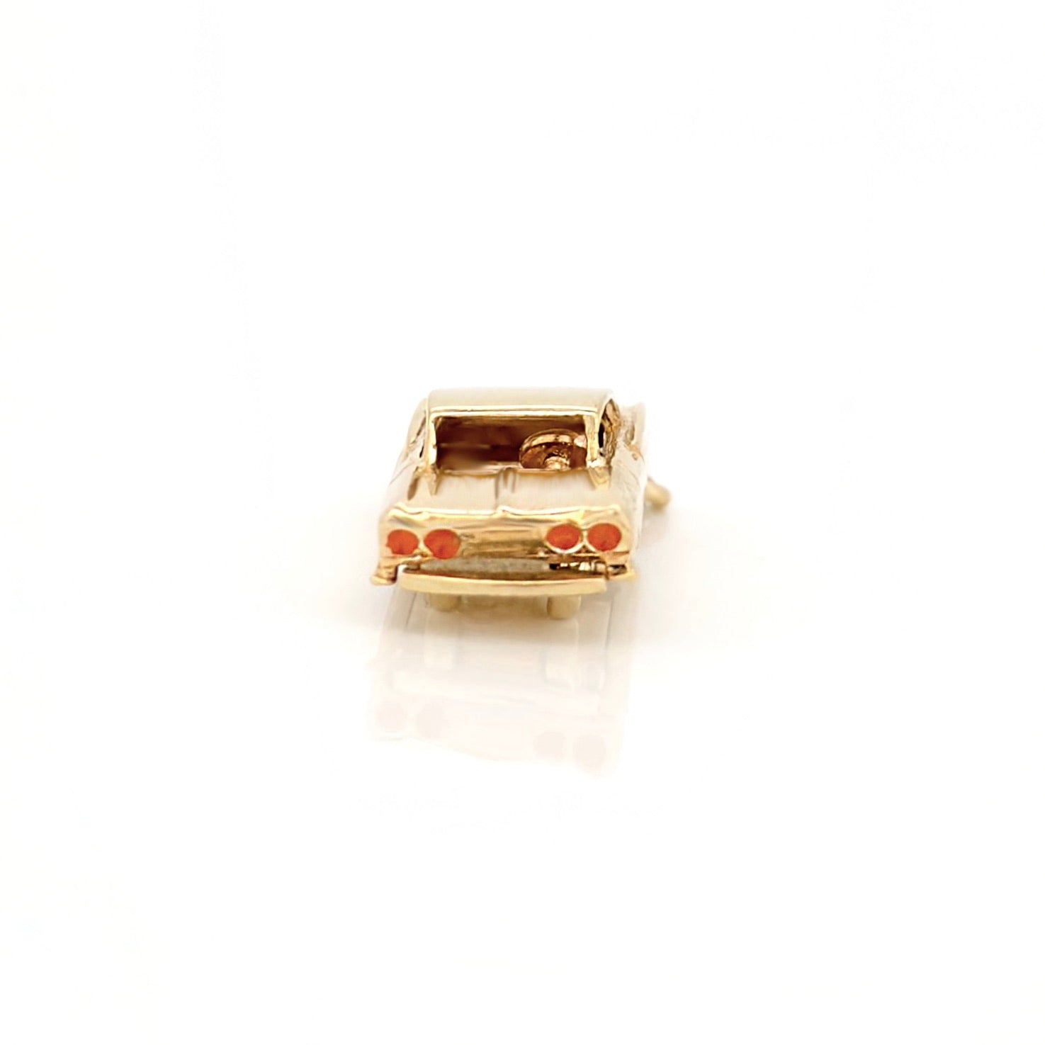 Gold car-shaped charm on a white background