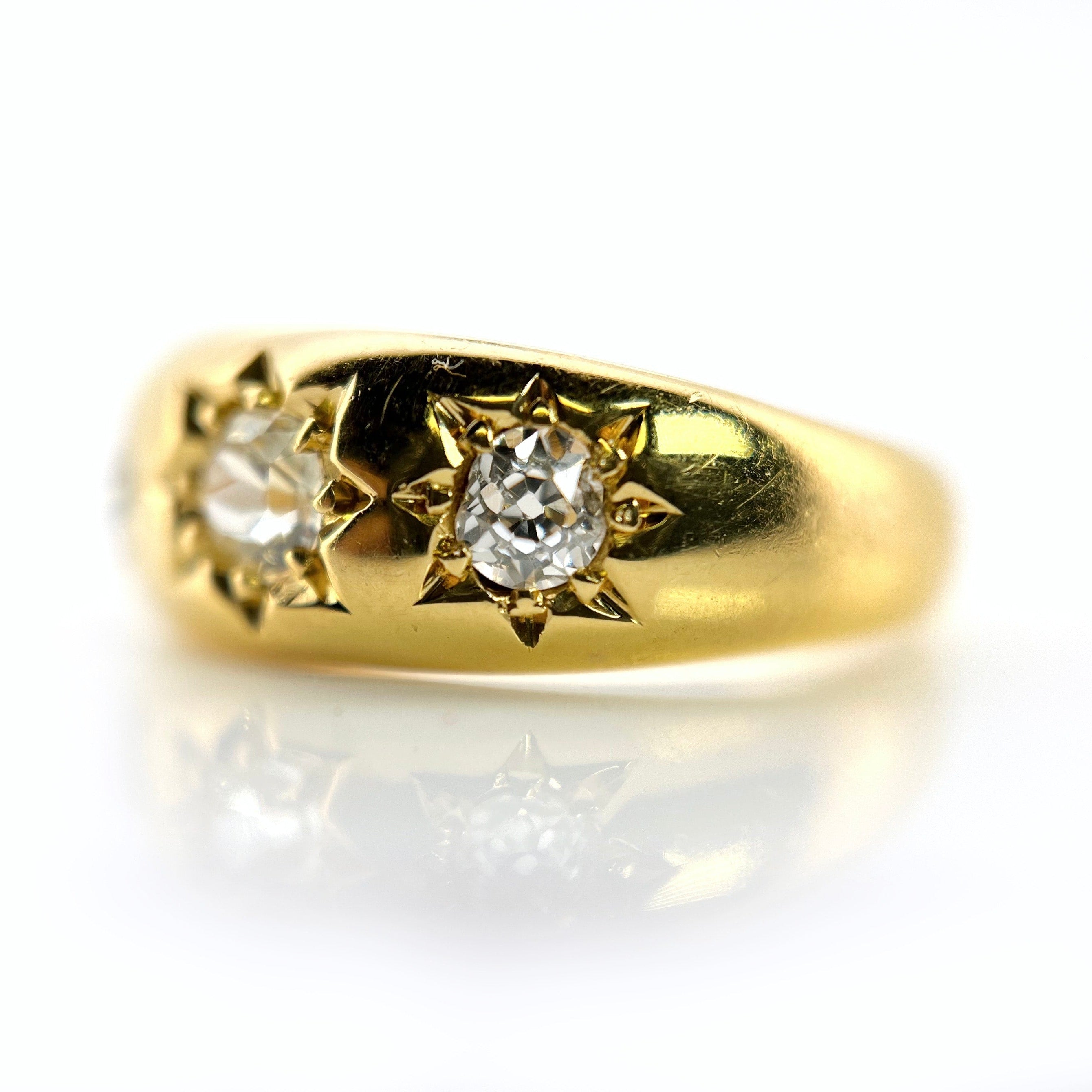A 22K gold old mine cut diamond celestial ring with three visible diamonds.
