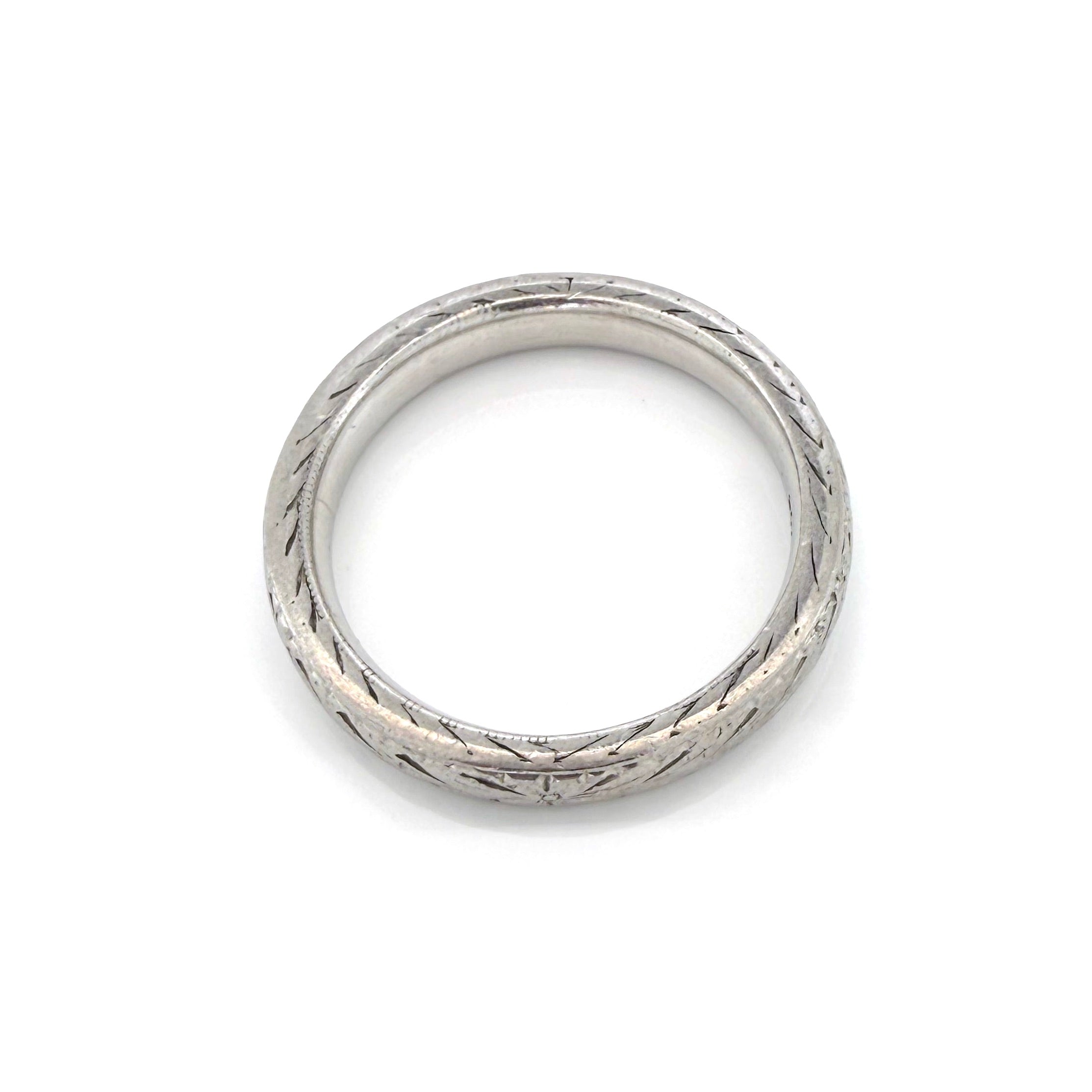 Vintage platinum ring with textured design on a white background