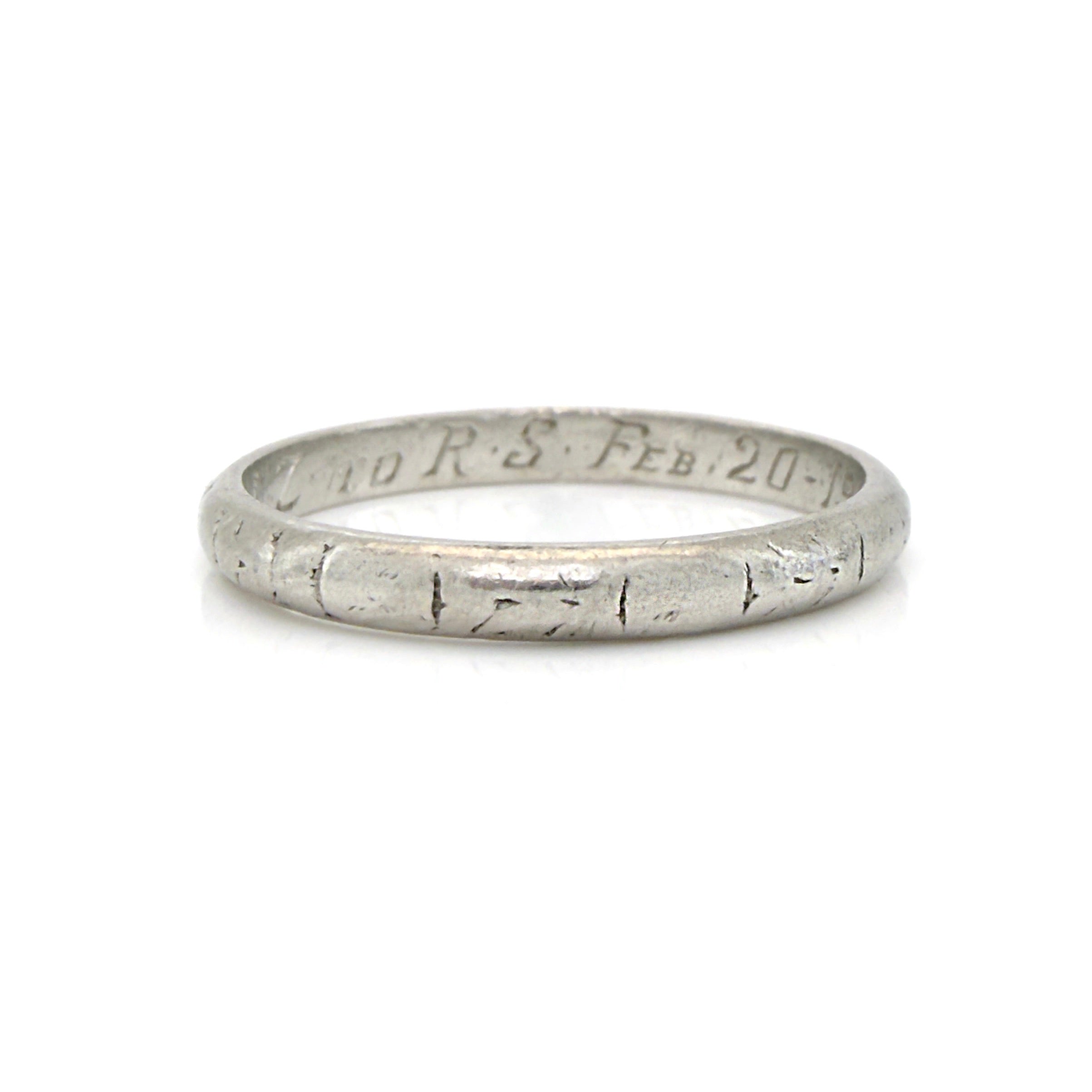 Art Deco platinum ring with engraved text on a white background