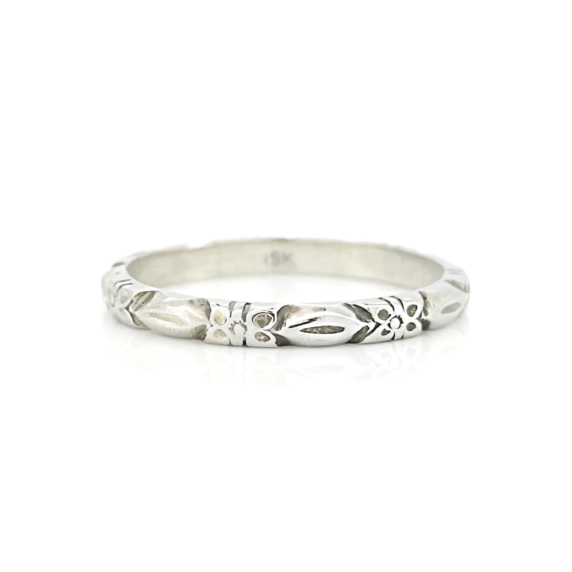 White gold ring with a flower pattern on a white background