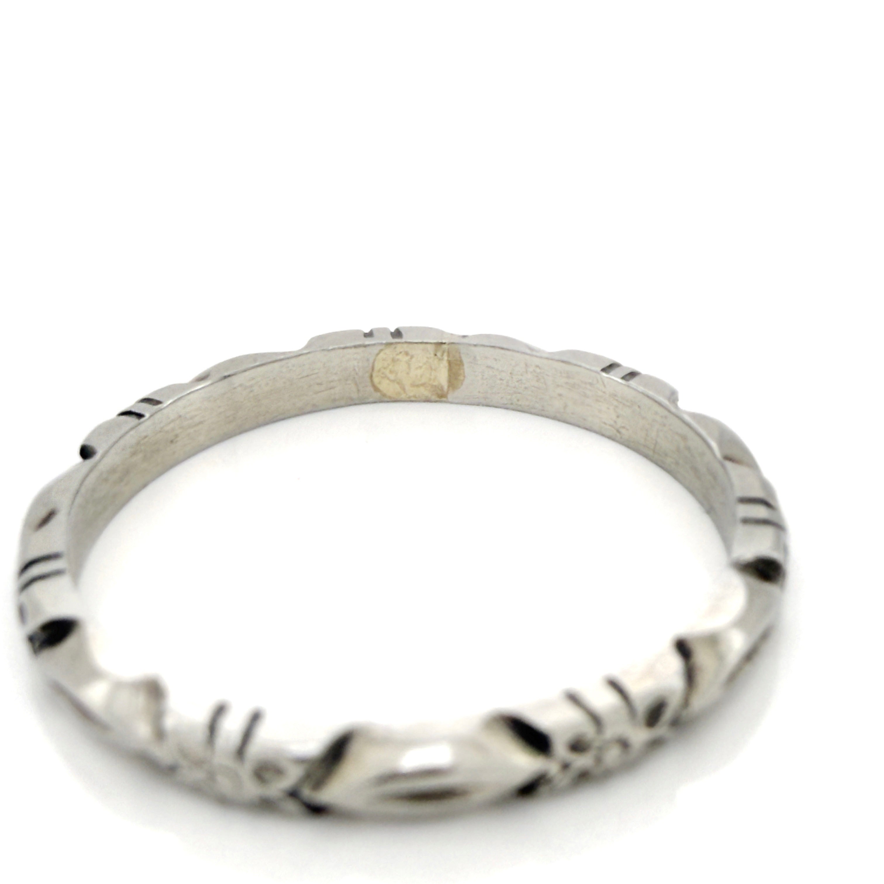 White gold ring with a flower pattern on a white background