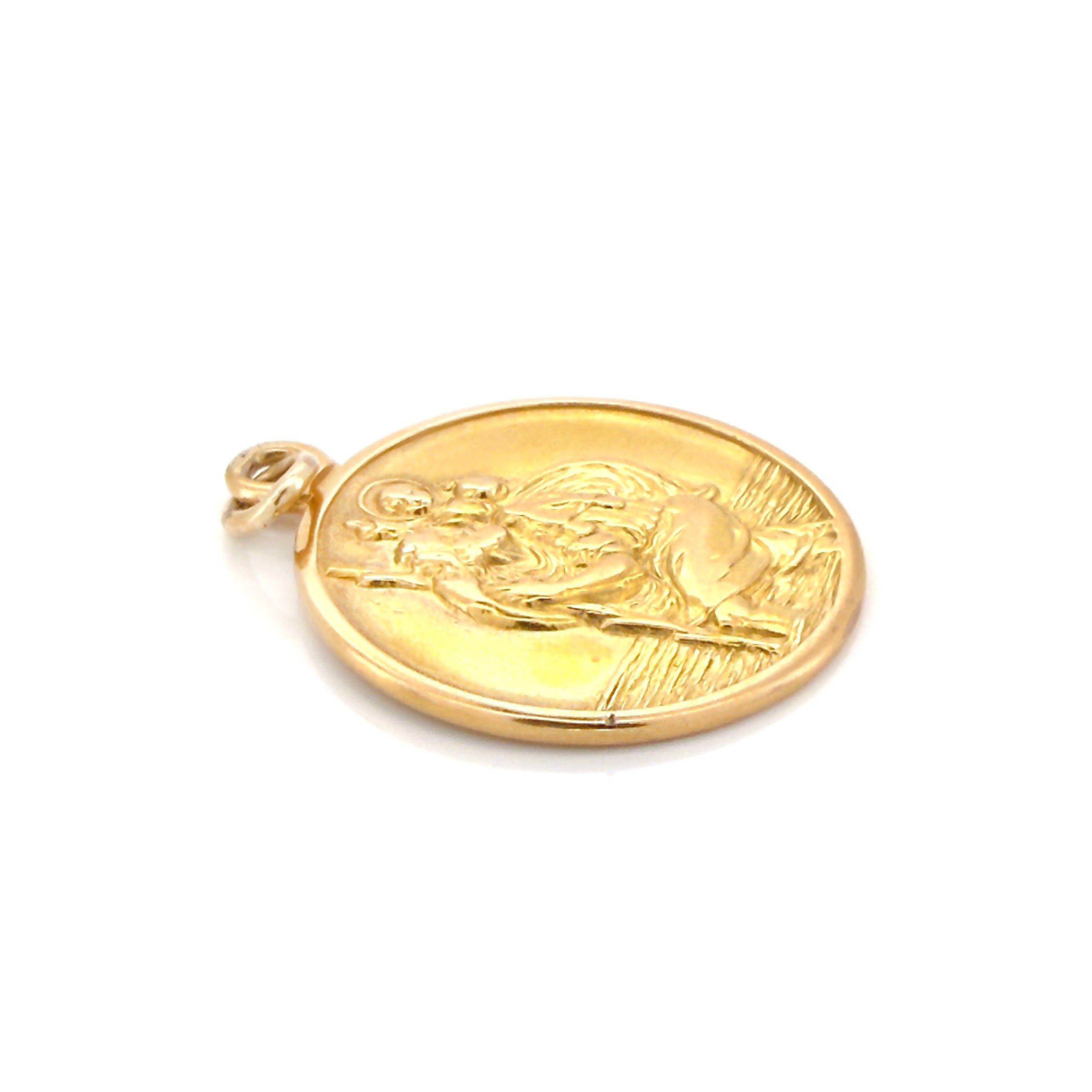 Vintage gold pendant with religious design on a white background