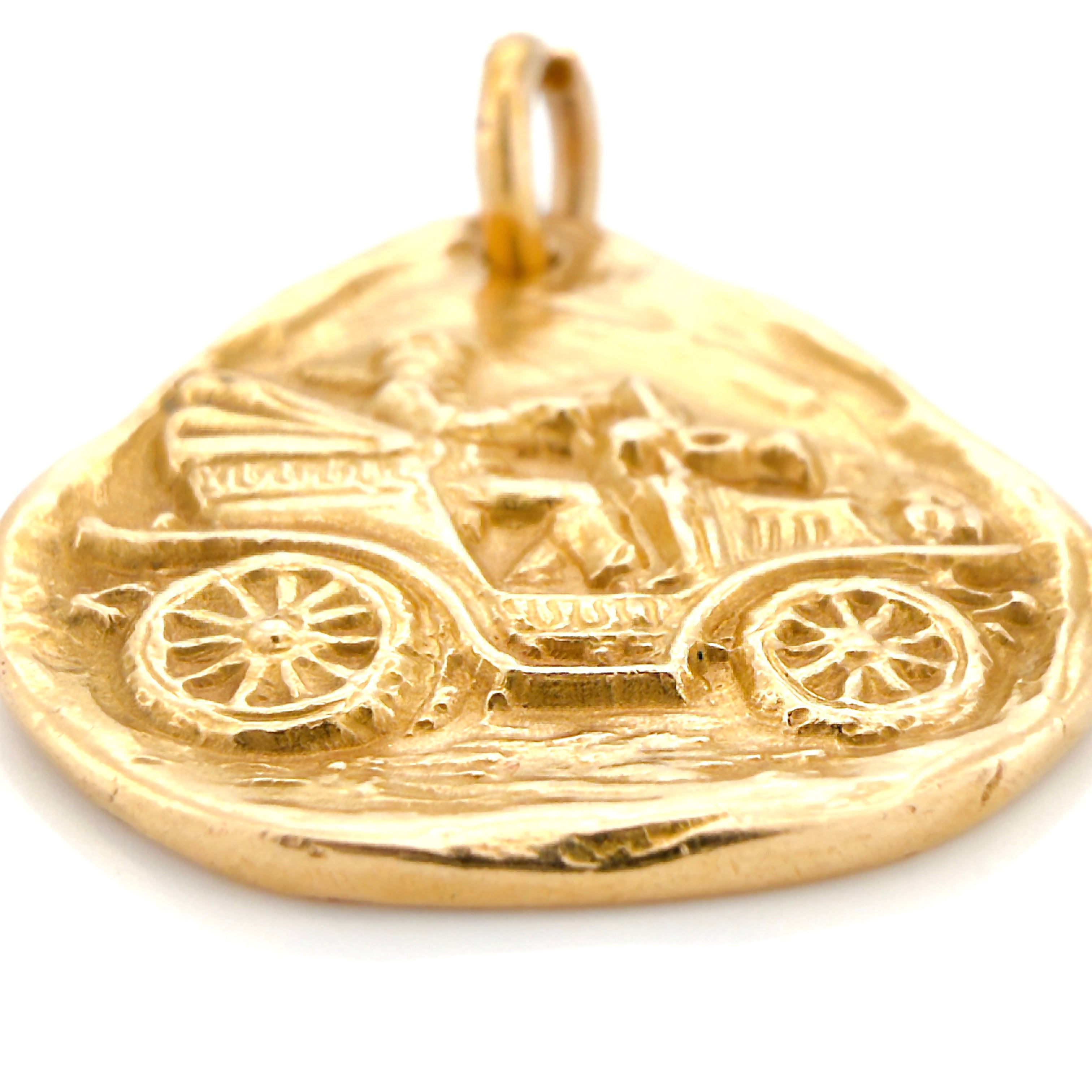 Gold pendant with vintage car design on a white background