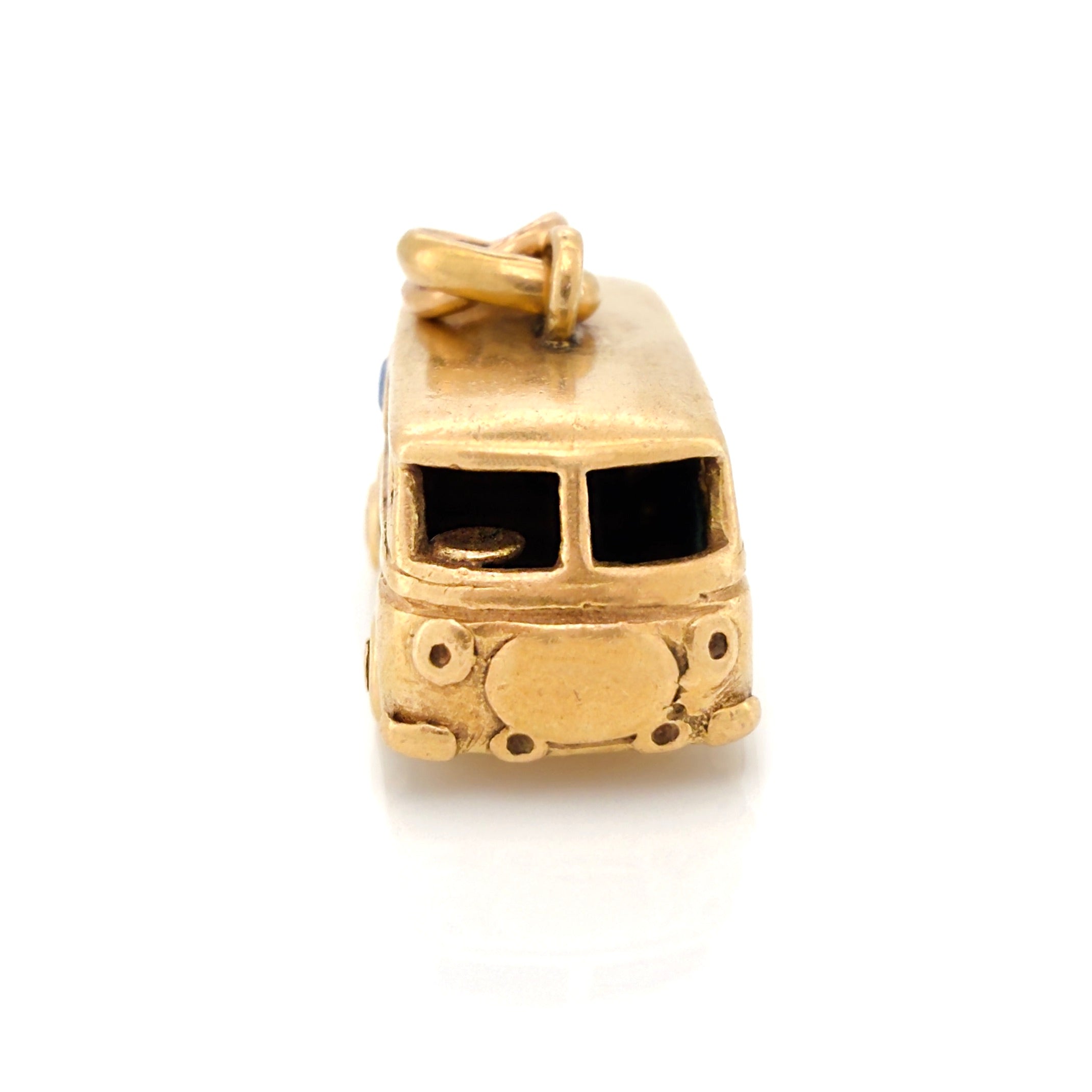Front view of a vintage gold microbus charm on a white background