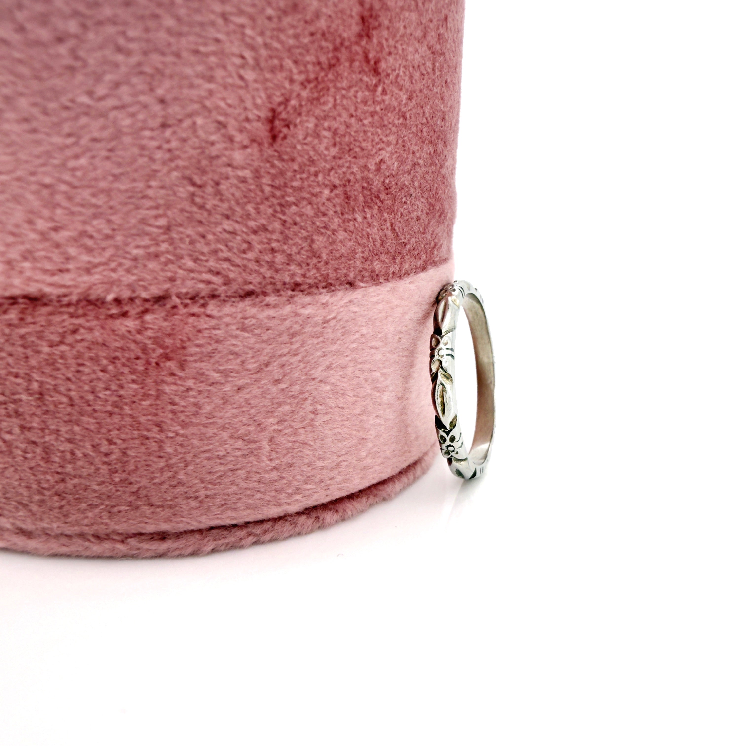 Vintage white gold ring on a pink fabric background