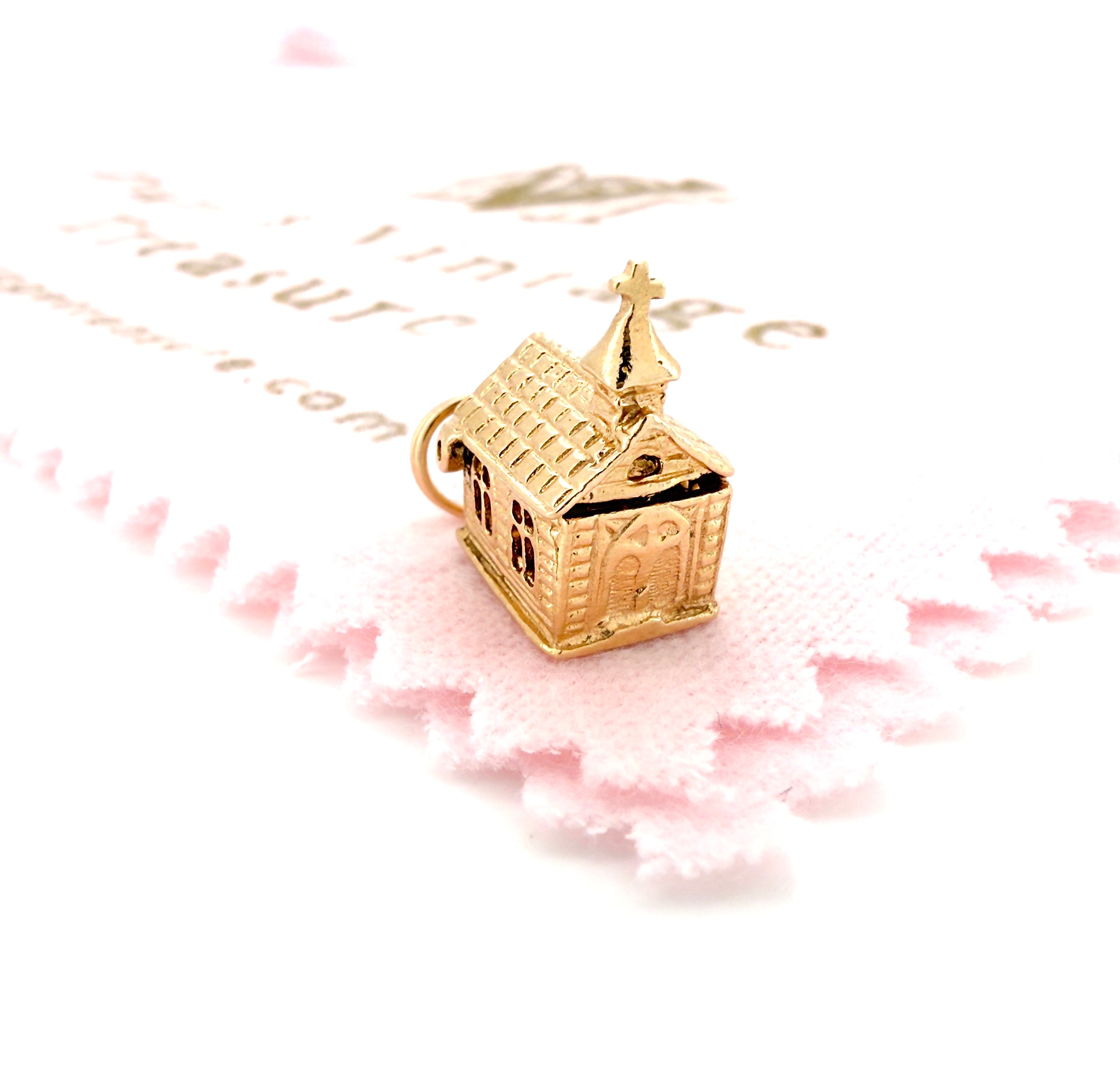 Gold church charm on a pink and white background