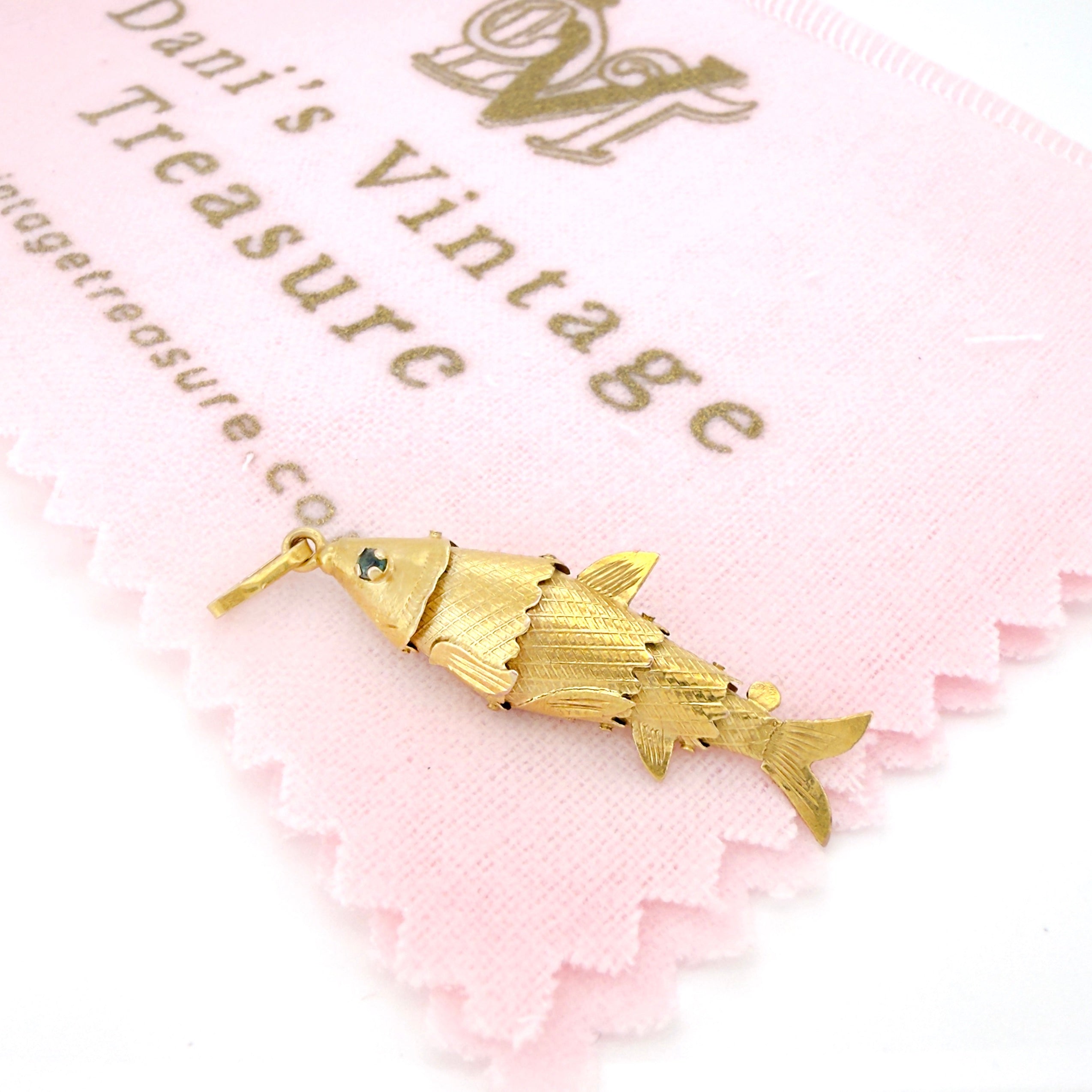Gold fish-shaped pendant on a pink background with 'Dani's Vintage' branding.