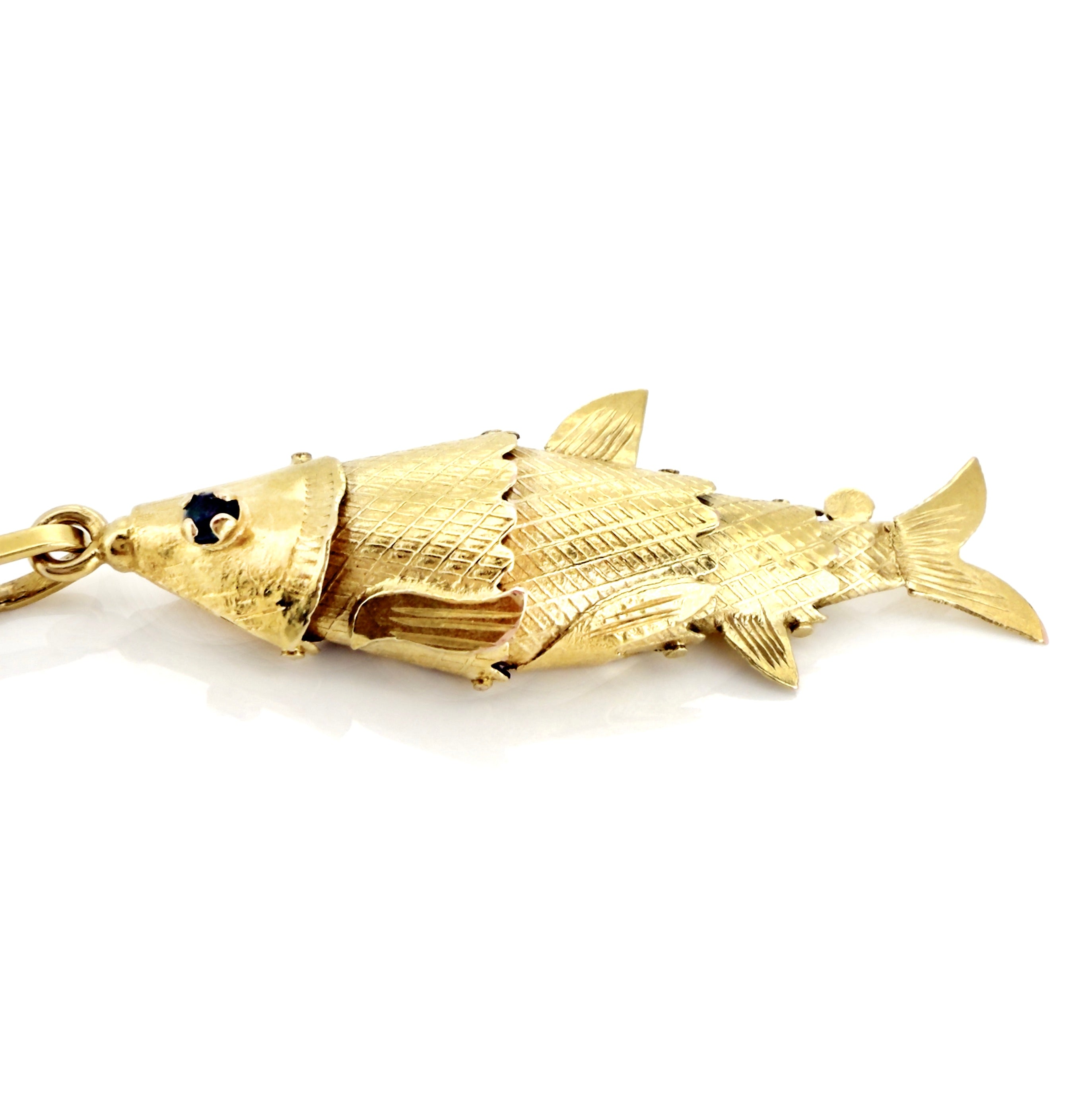 Gold fish-shaped pendant on a white background