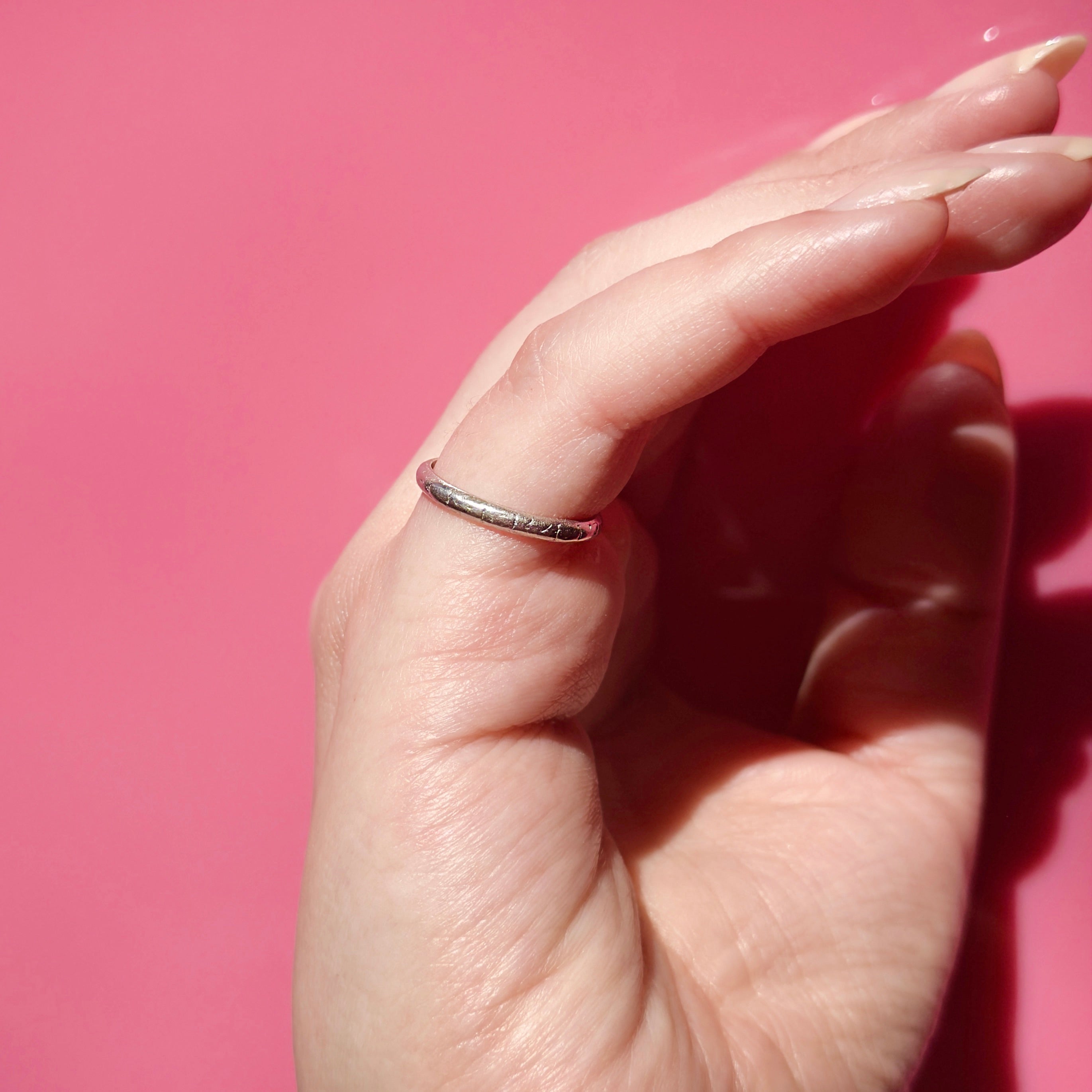 Hand wearing an Art Deco Platinum ring on a pink background