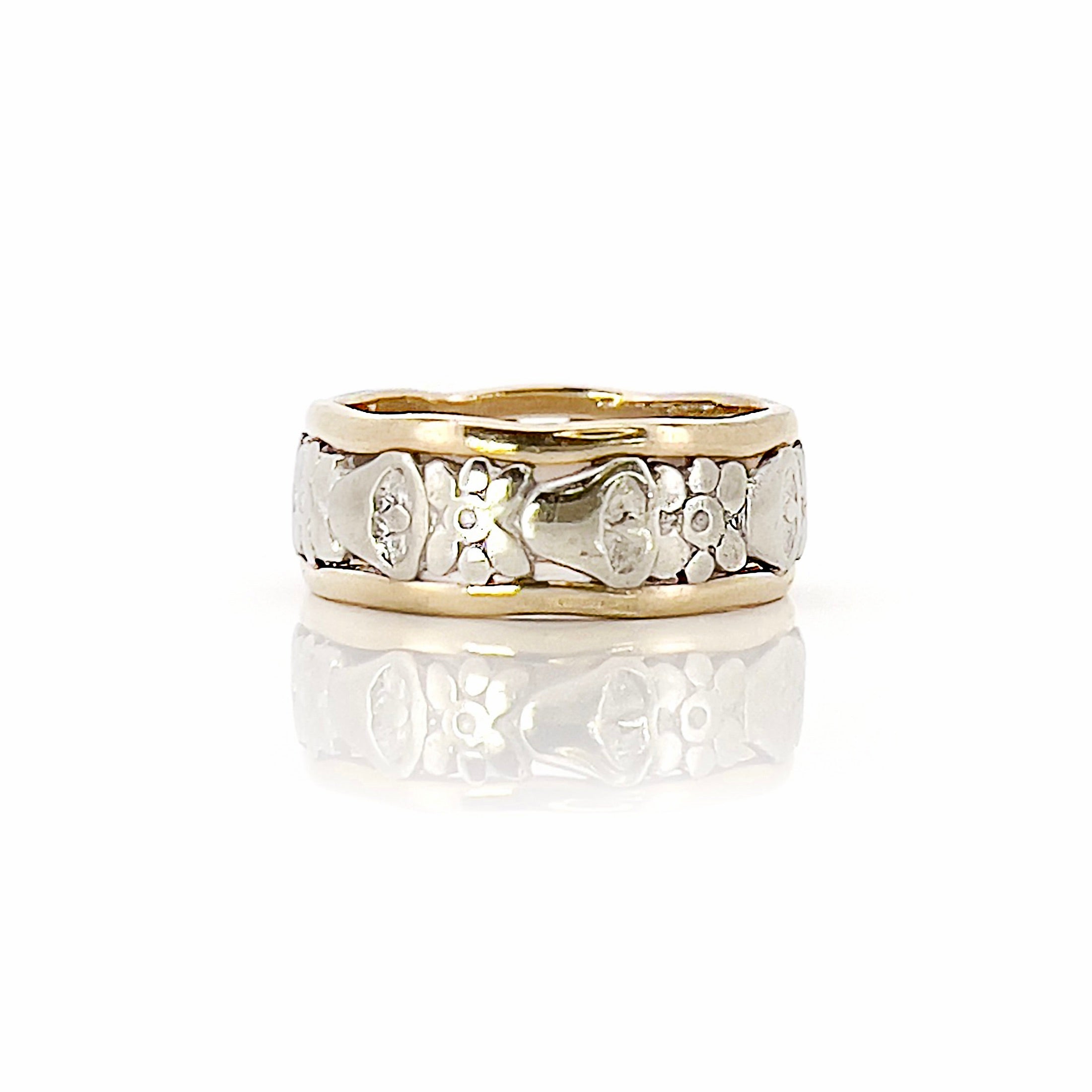 Two-tone gold ring with floral design on a white background