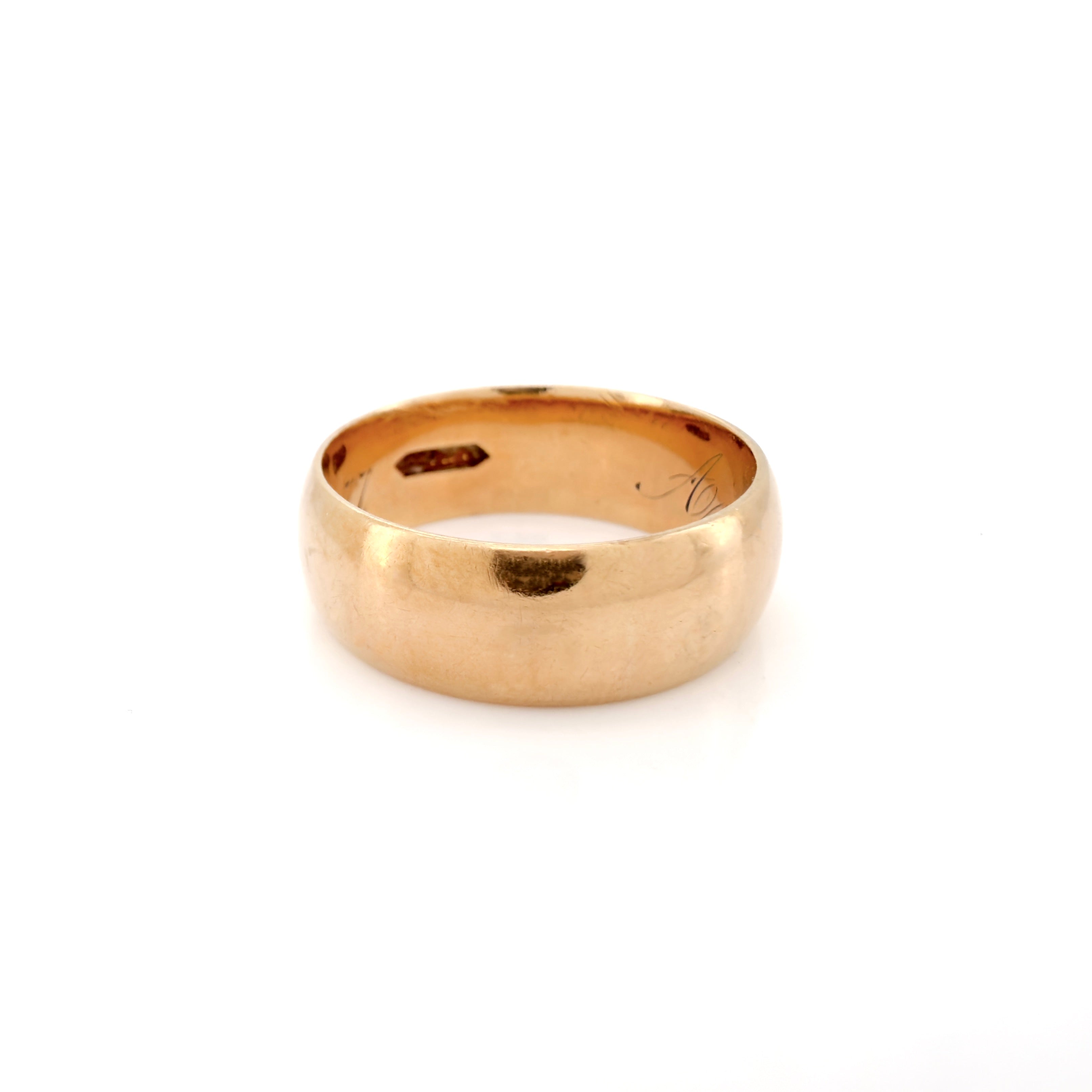A classic Victorian cigar yellow gold band ring with a smooth, polished finish, photographed on a clean white background.