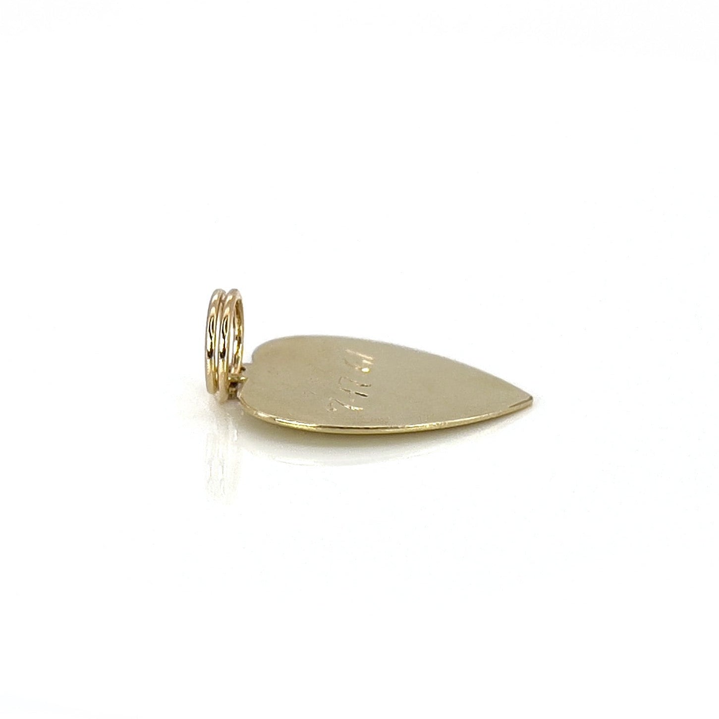 A vintage gold heart-shaped charm with the inscription 'Susan Marie' and a date '7-17-61' engraved on it.