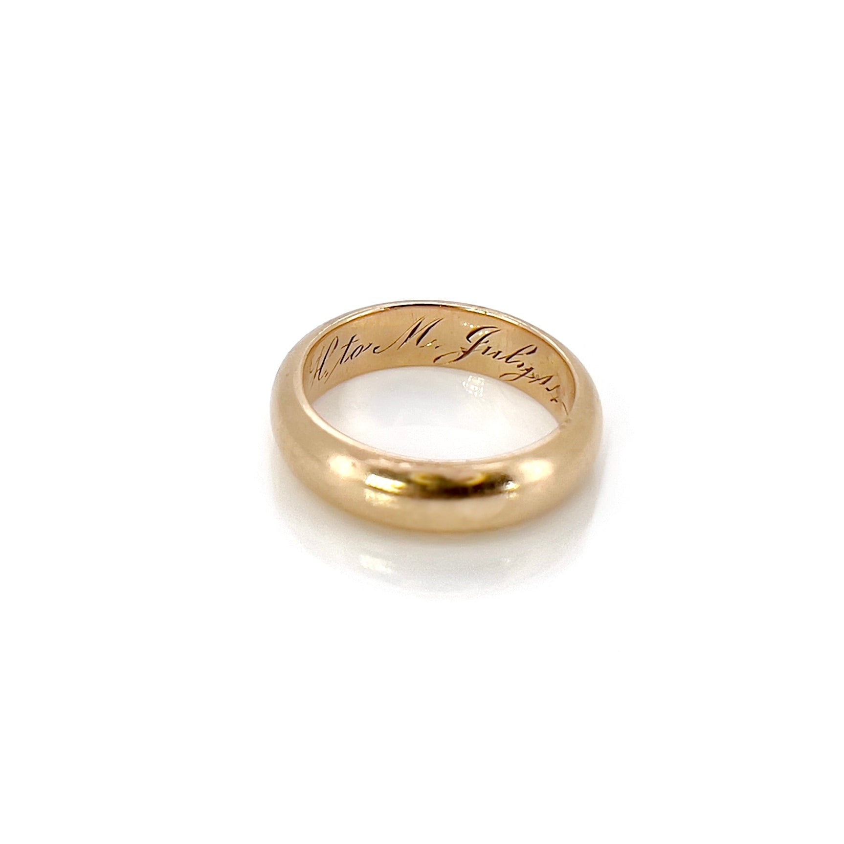 An antique gold band with an inscription, displayed against a white background.