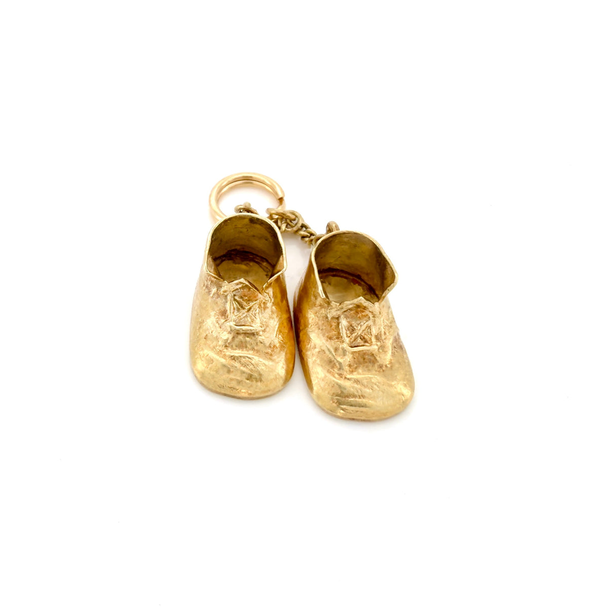 A pair of small gold baby boot charm with a textured finish, attached to a gold split ring, shown on a plain white background.