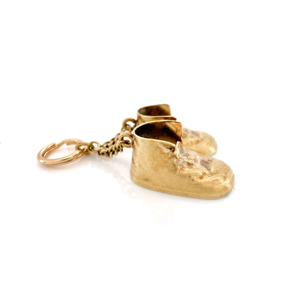 A pair of miniature gold baby boot charms with a textured finish, attached to a gold chain and split key ring, shown on a clean white background.