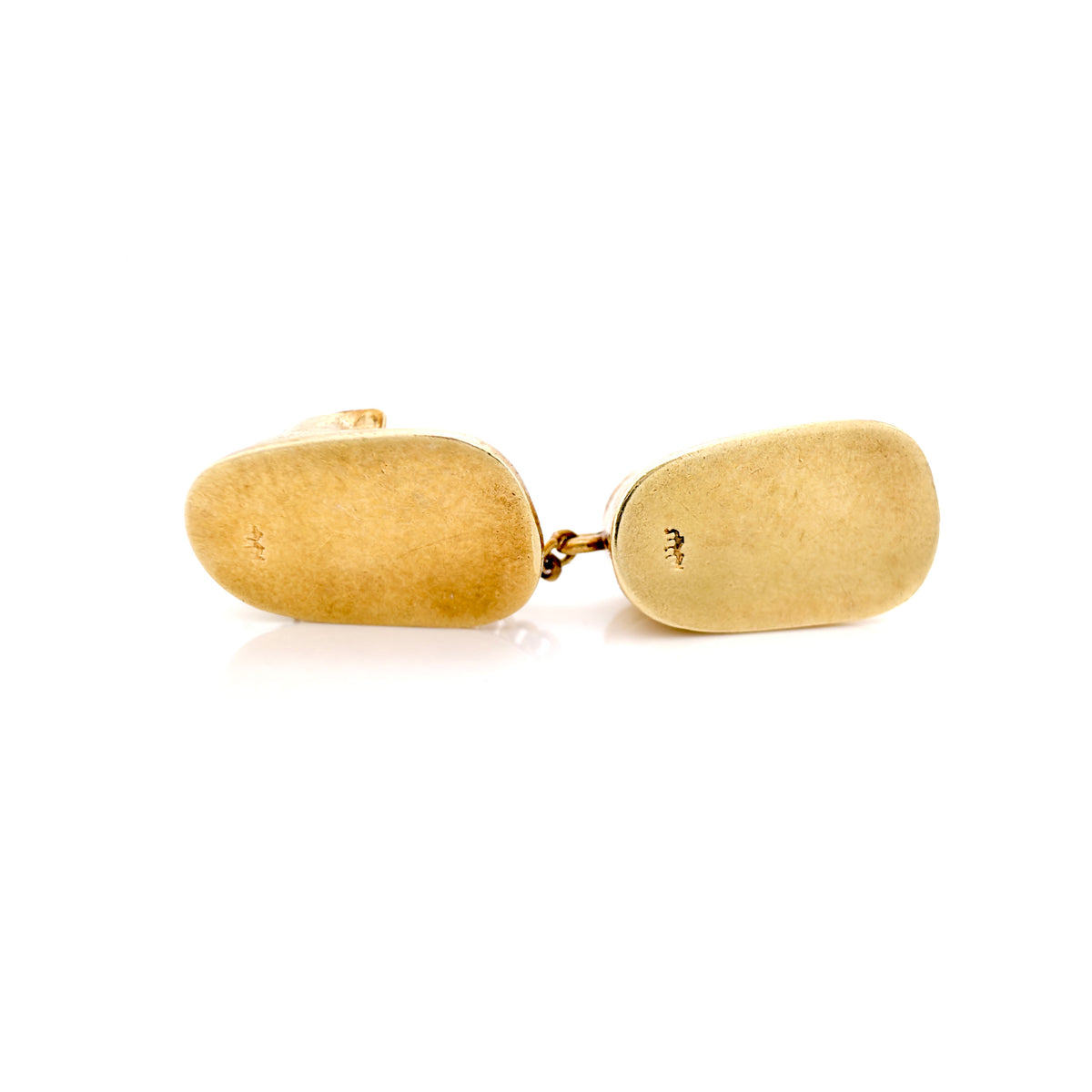 Bottom of two gold baby boots against a white background.
