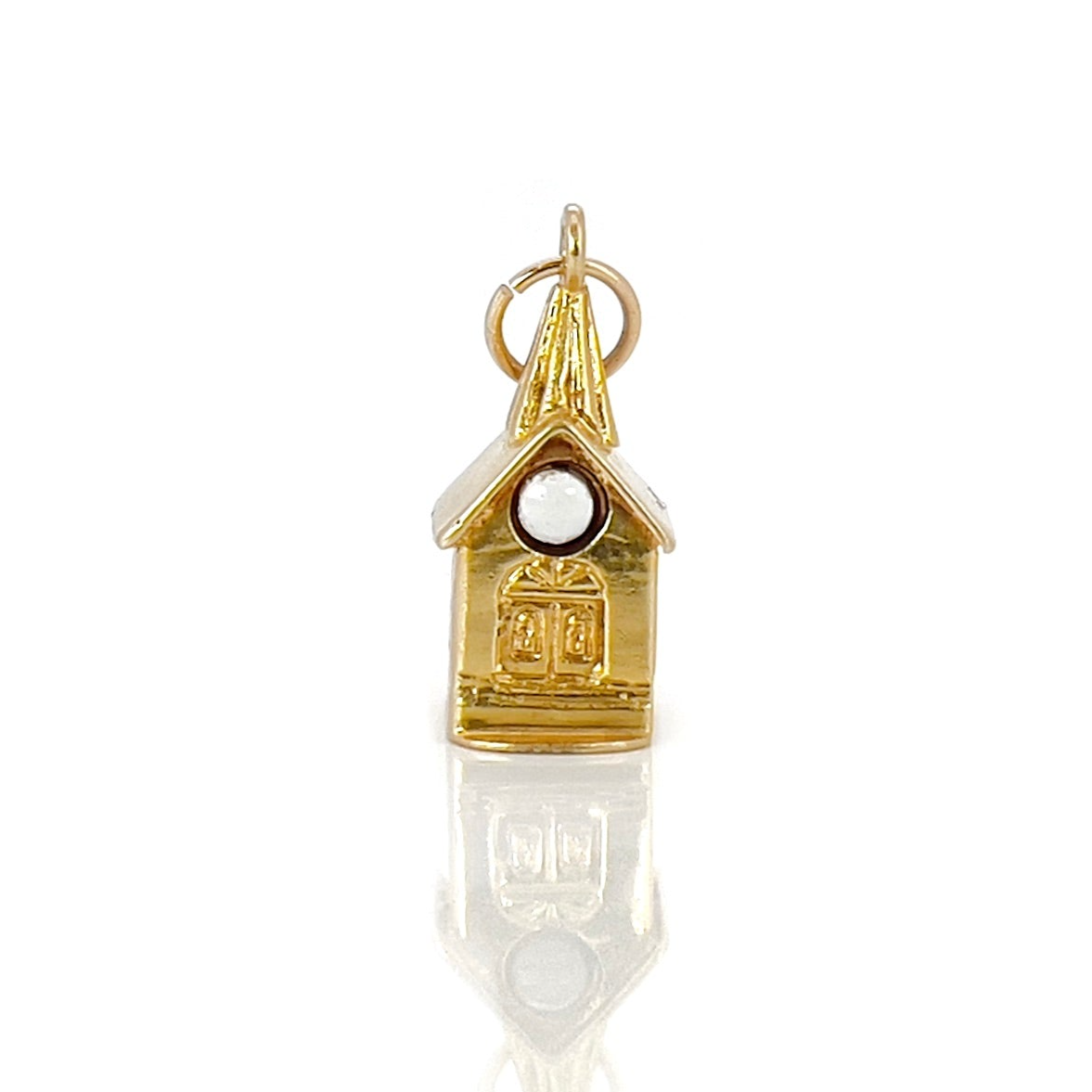 A vintage 14K yellow gold charm shaped like a chapel with a stanhope viewer.