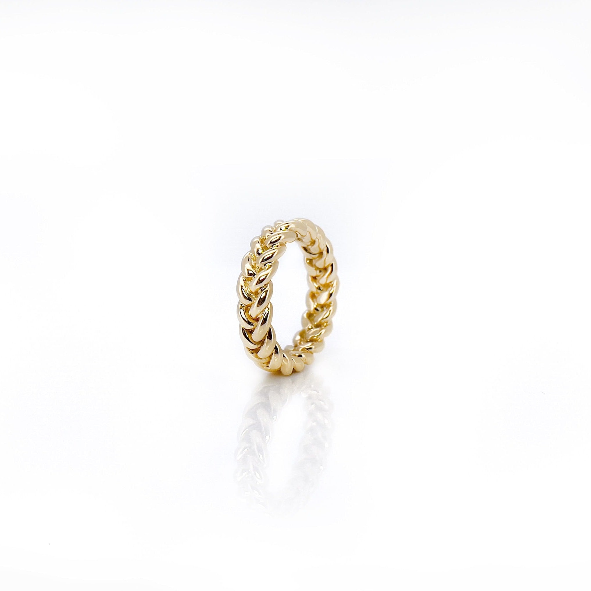 Side view of a braided gold vintage ring with a white background.