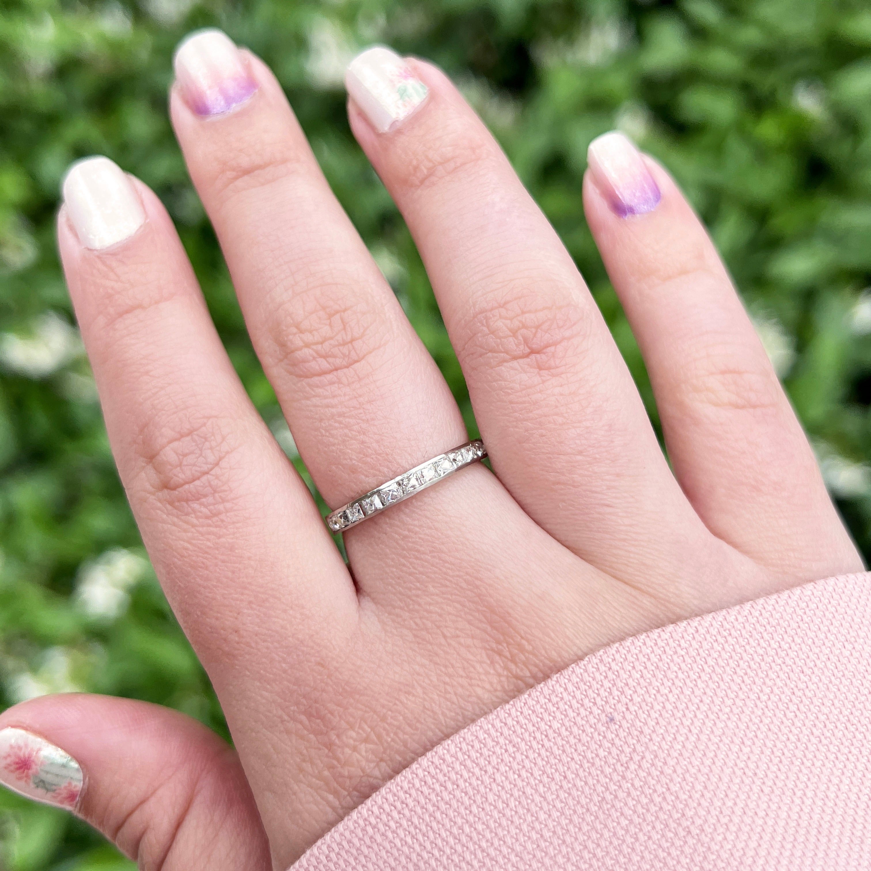 Hand wearing an Art Deco french cut diamond band made out of platinum