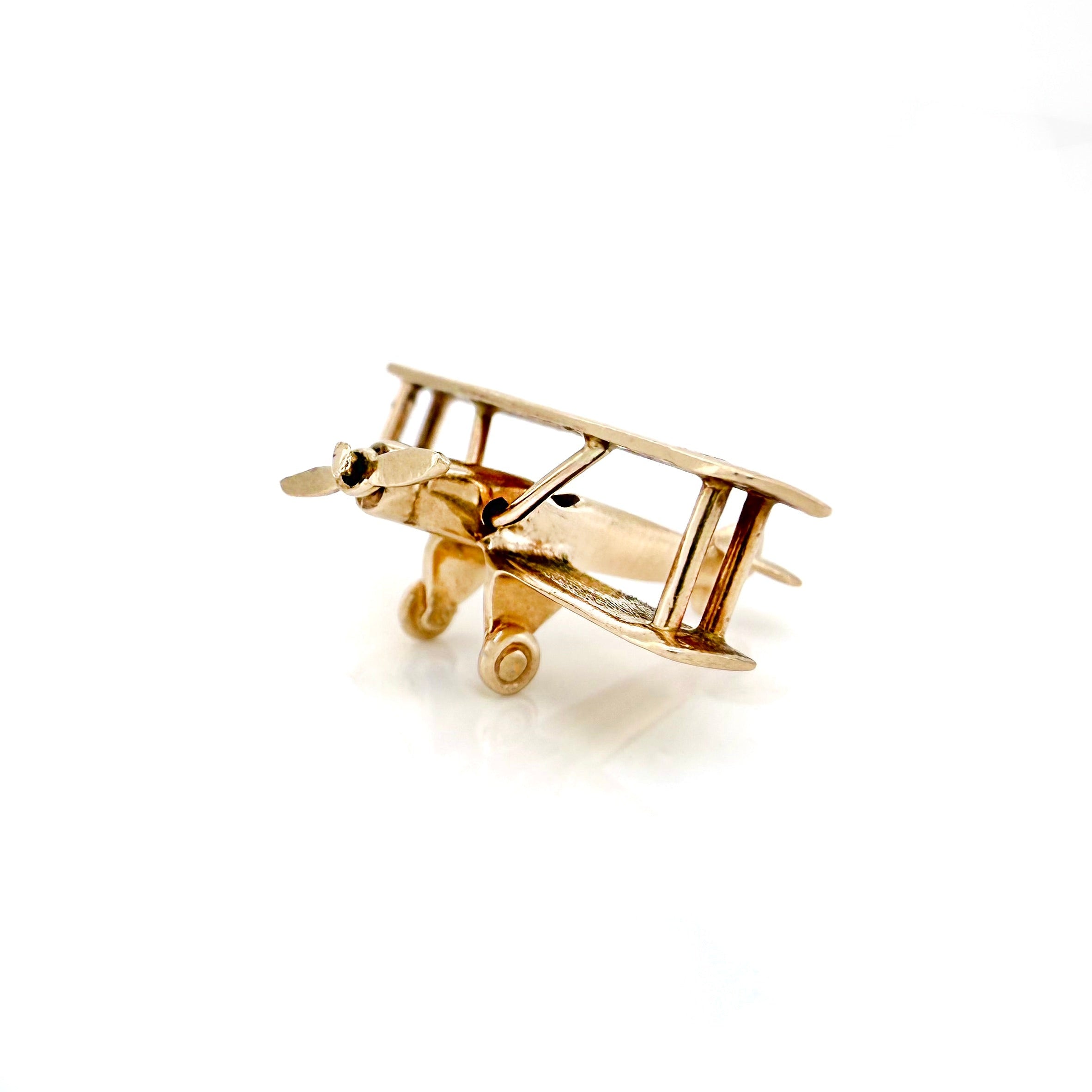 Gold airplane-shaped pendant on a white background