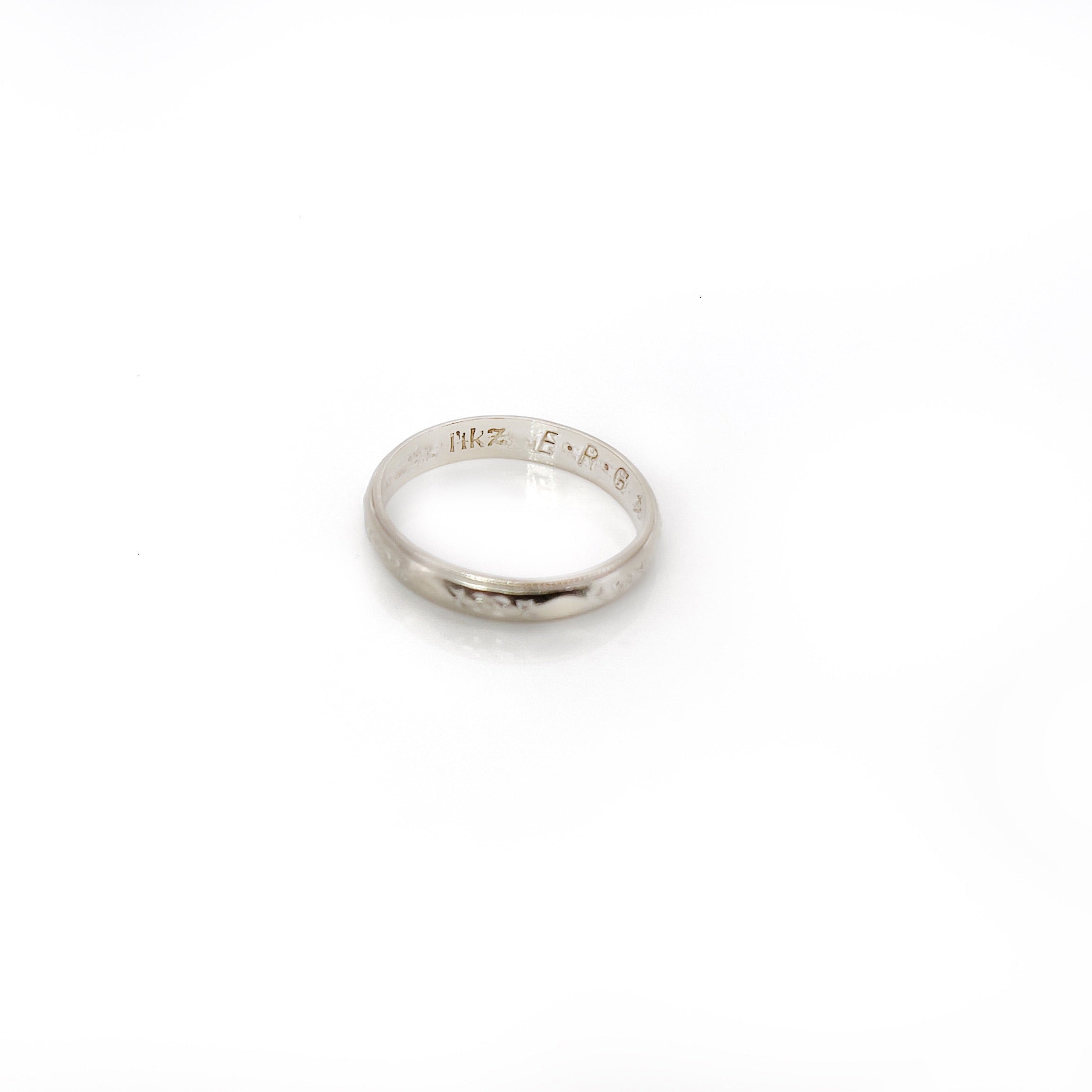 A vintage white gold ring with faint orange blossom design and milgrain pattern, size 5.25, with visible wear.