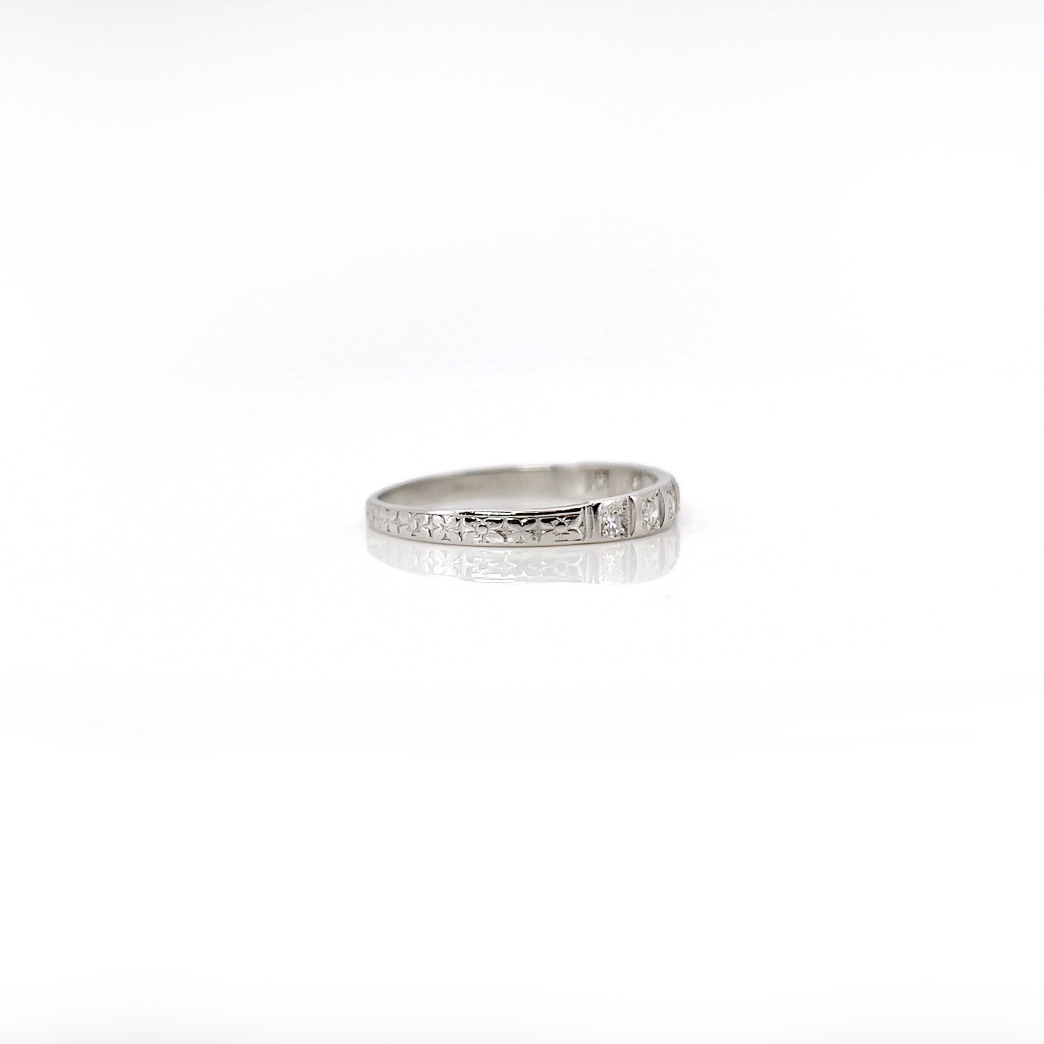 Art deco 7 single cut diamond platinum wedding band against a white background. 