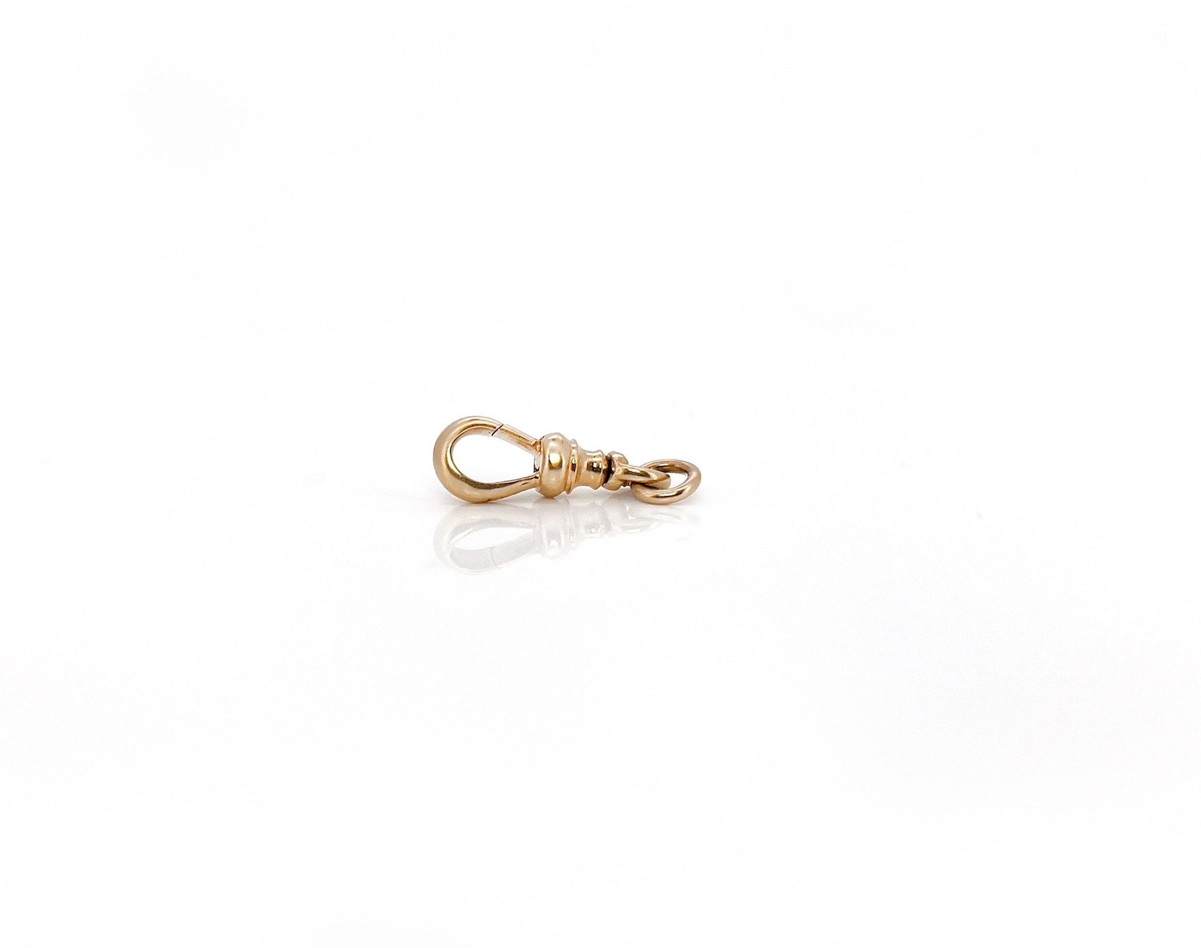 Antique gold swivel dog clip with a seamless swivel design and a 14K stamp.