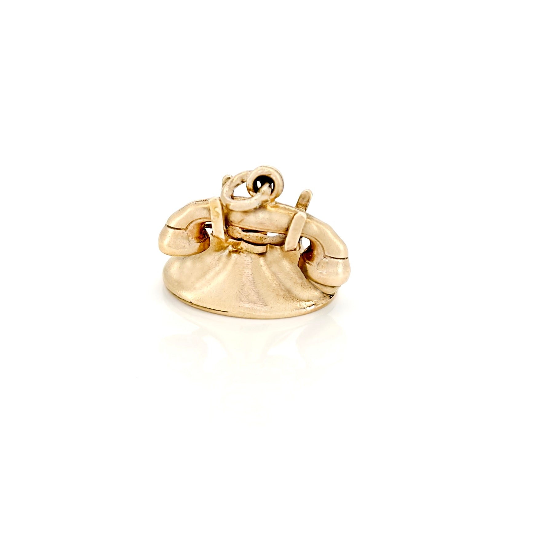 Gold charm shaped like a vintage phone on a white background