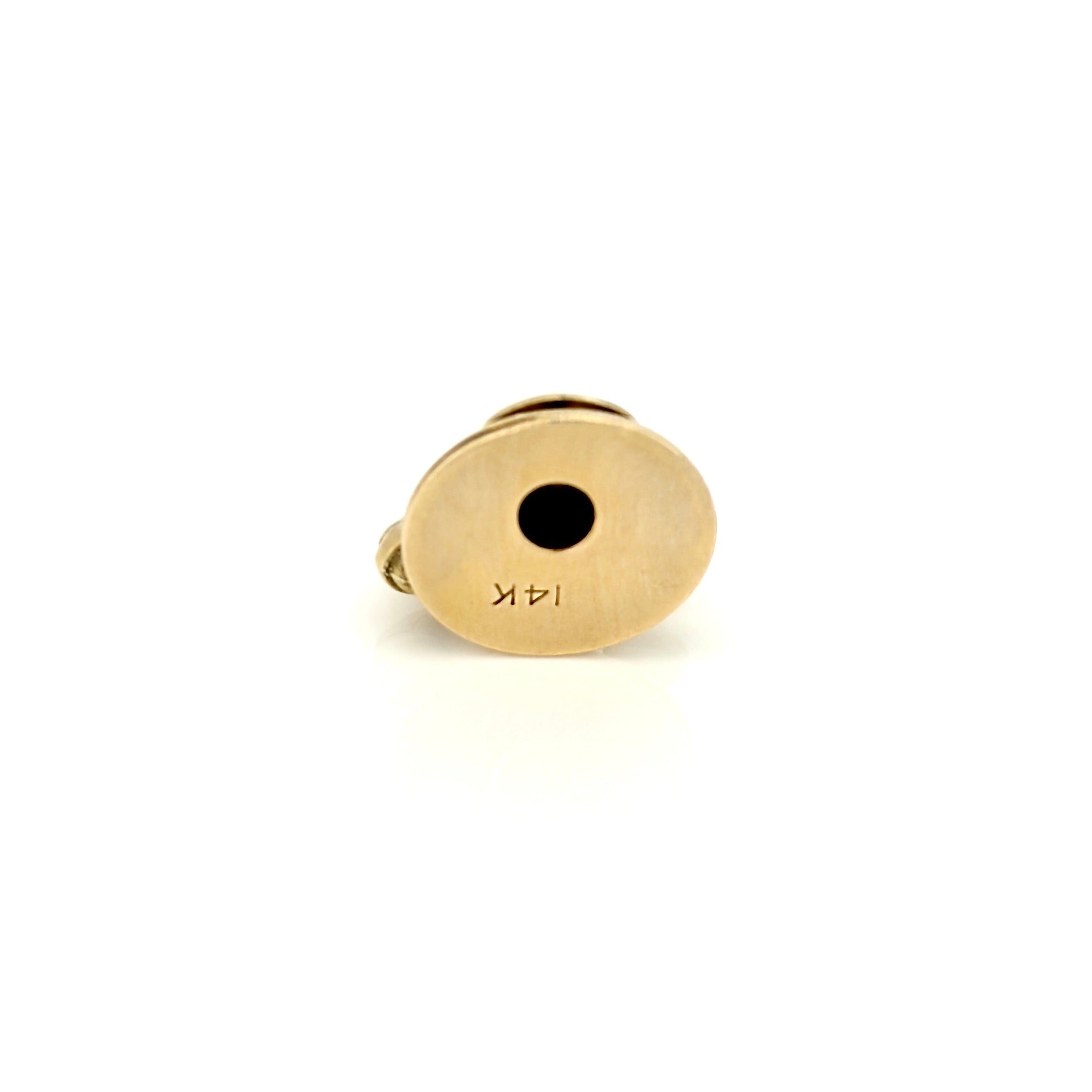 Bottom of gold vintage telephone charm against white background