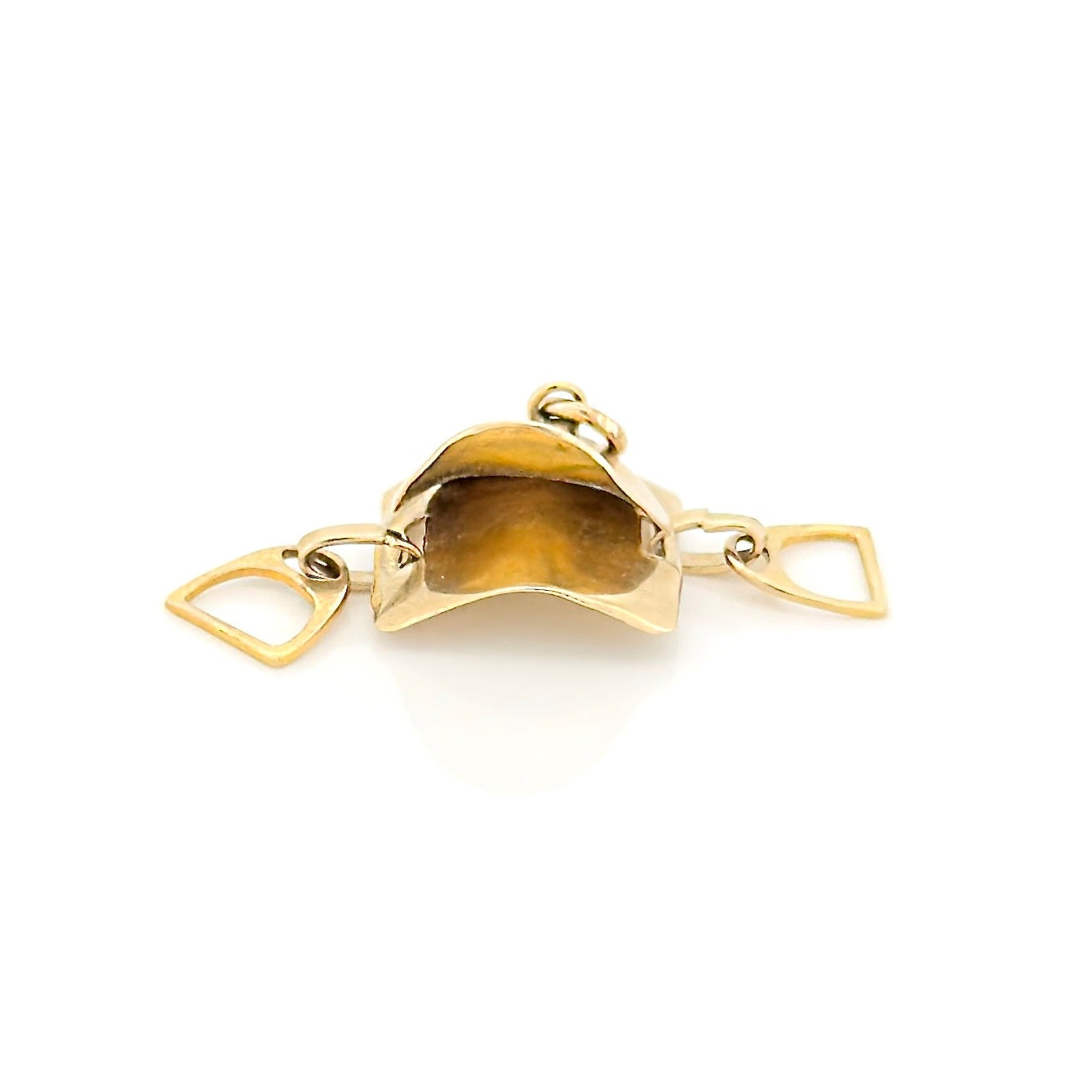 Gold saddle charm on a white background