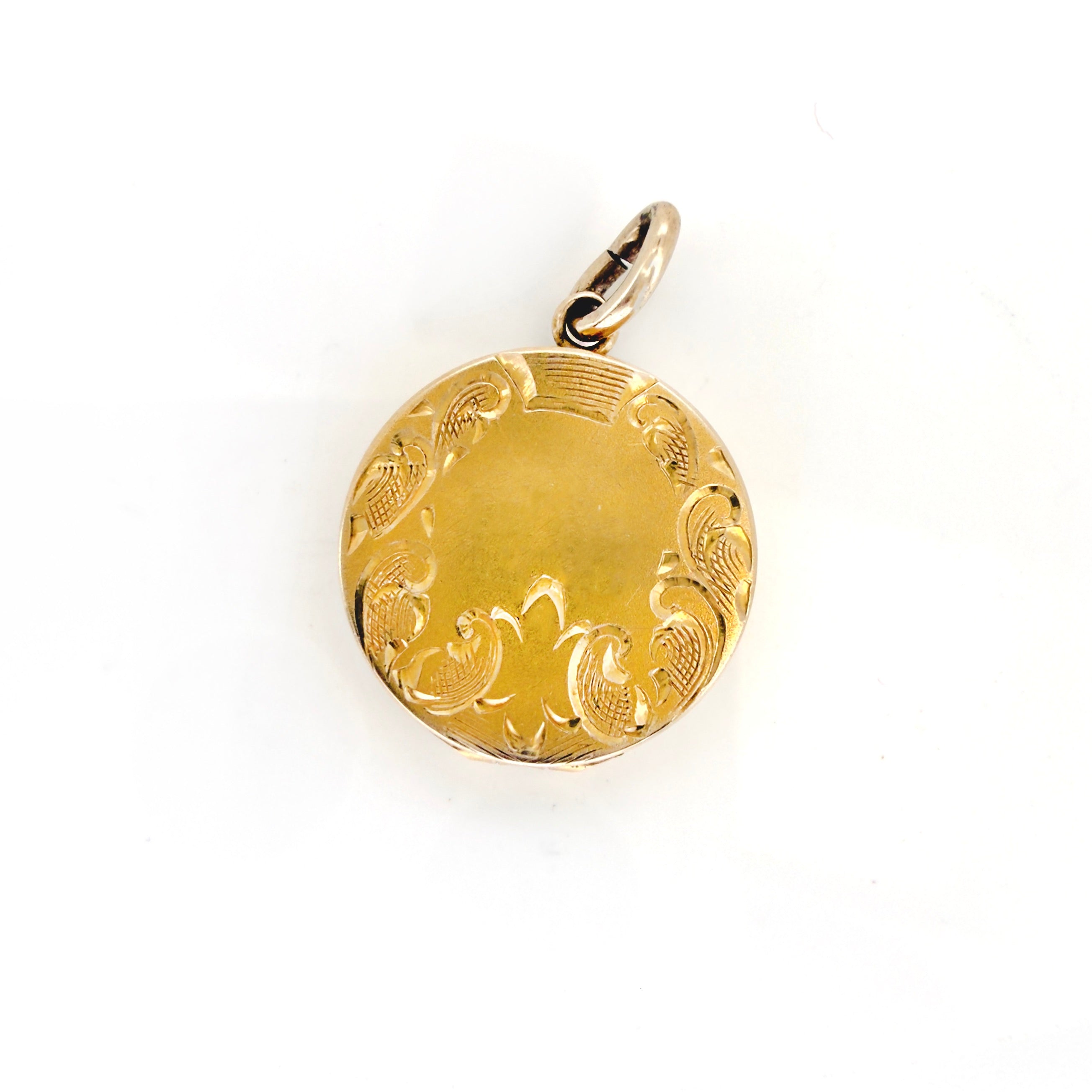 Gold locket with intricate designs on a white background