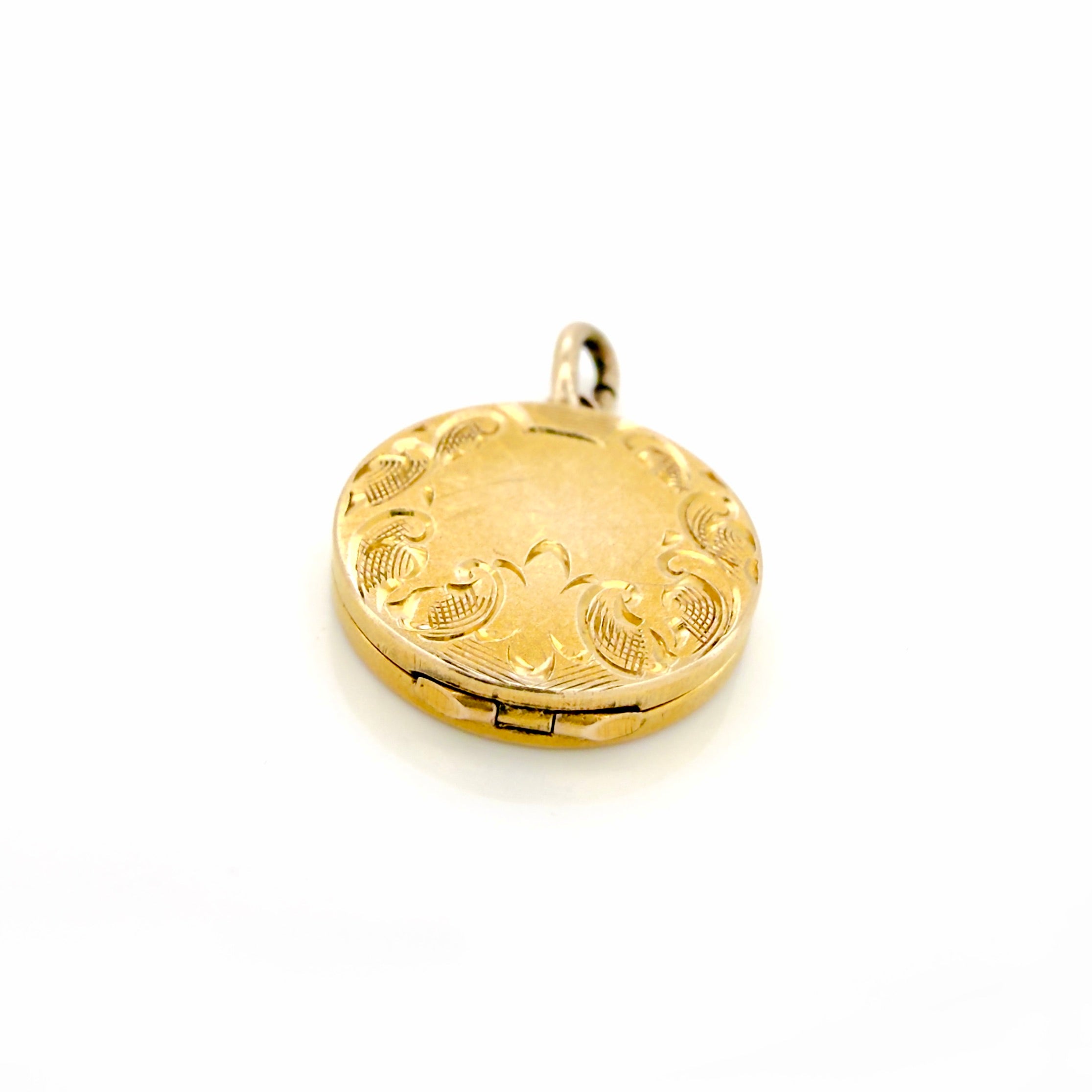 Gold locket with intricate designs on a white background