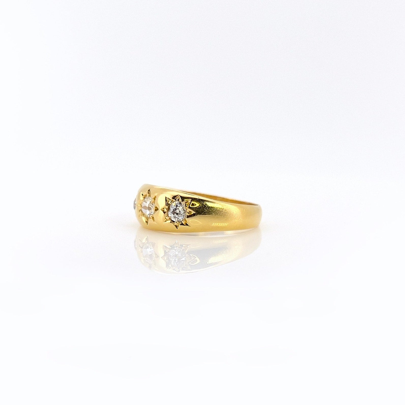 A 22K gold old mine cut diamond celestial ring with three visible diamonds.