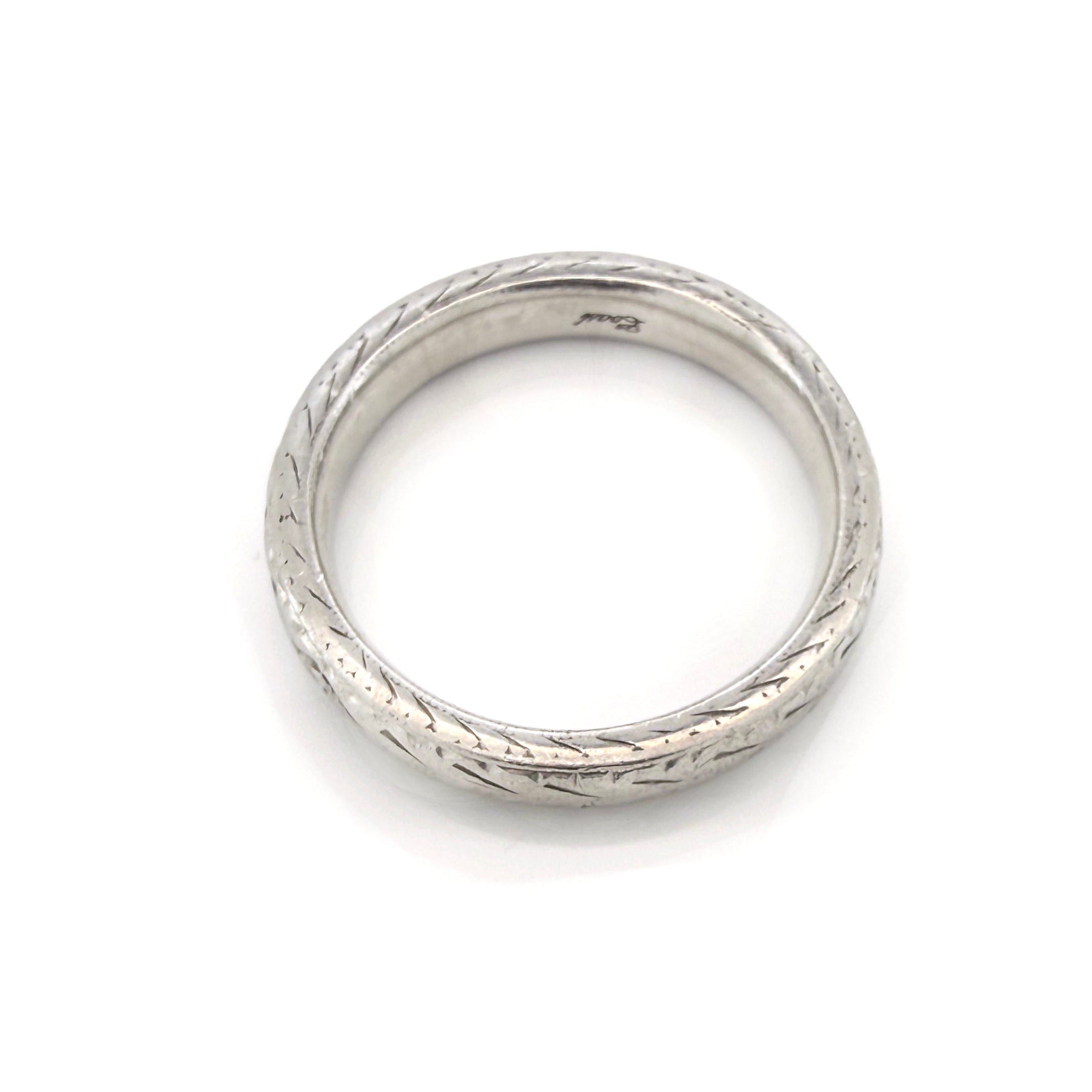 Vintage platinum ring with textured design on a white background