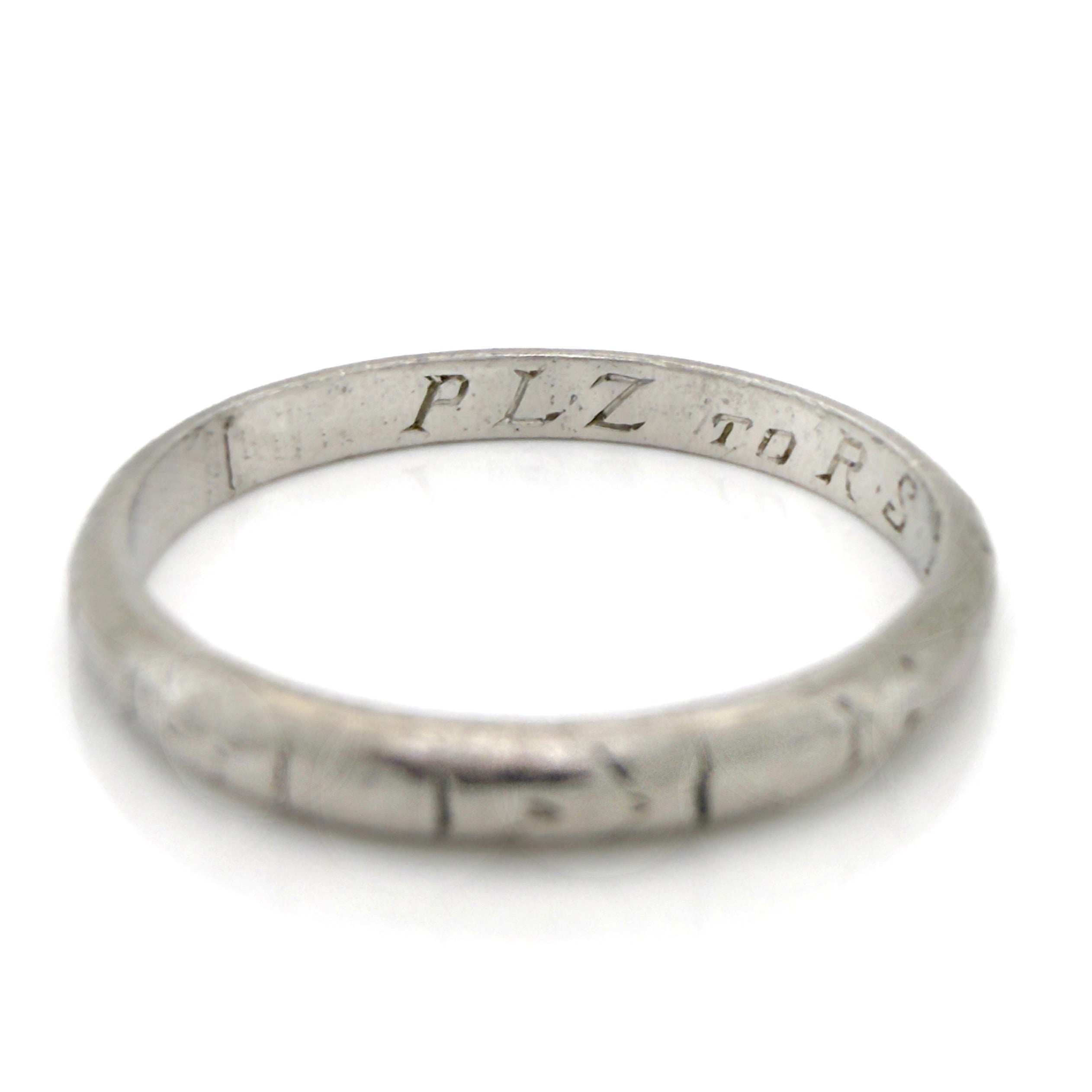 Art Deco platinum ring with engraved text on a white background